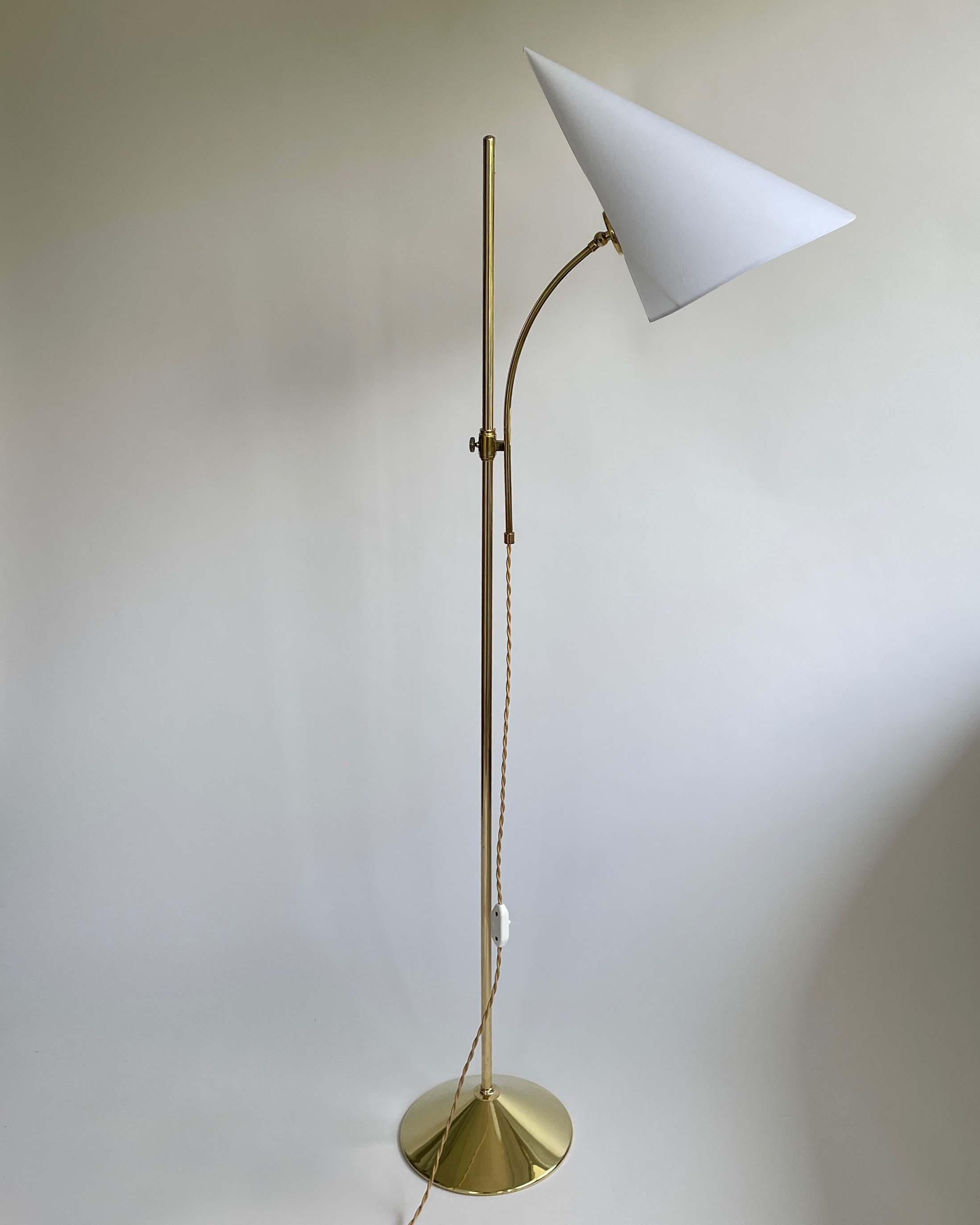 Ce lampadaire inhabituel The Scandinavian Modern a été conçu et fabriqué en Suède dans les années 1950. Elle est dotée d'une base en laiton et d'un abat-jour en coton blanc réglable en hauteur. 

La lampe nécessite une ampoule E27 jusqu'à 60 Watt