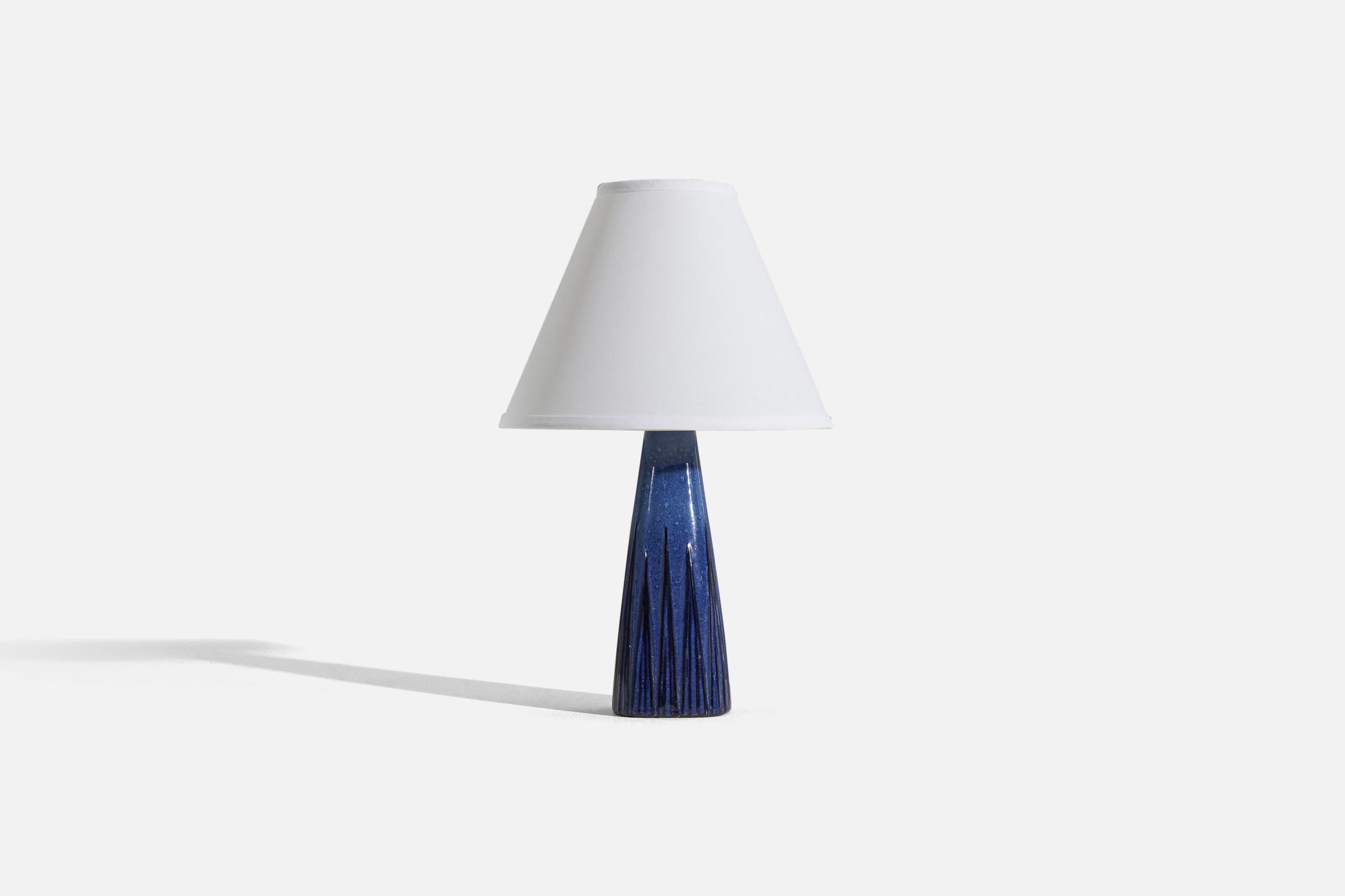 A blue, glazed stoneware table lamp, designed and produced by a Swedish designer, Sweden, 1960s.

Sold without lampshade. 
Dimensions of Lamp (inches) : 12.18 75 x 3.375 x 3.375 (H x W x D)
Dimensions of Shade (inches) : 4.25 x 10.25 x 8 (T x B