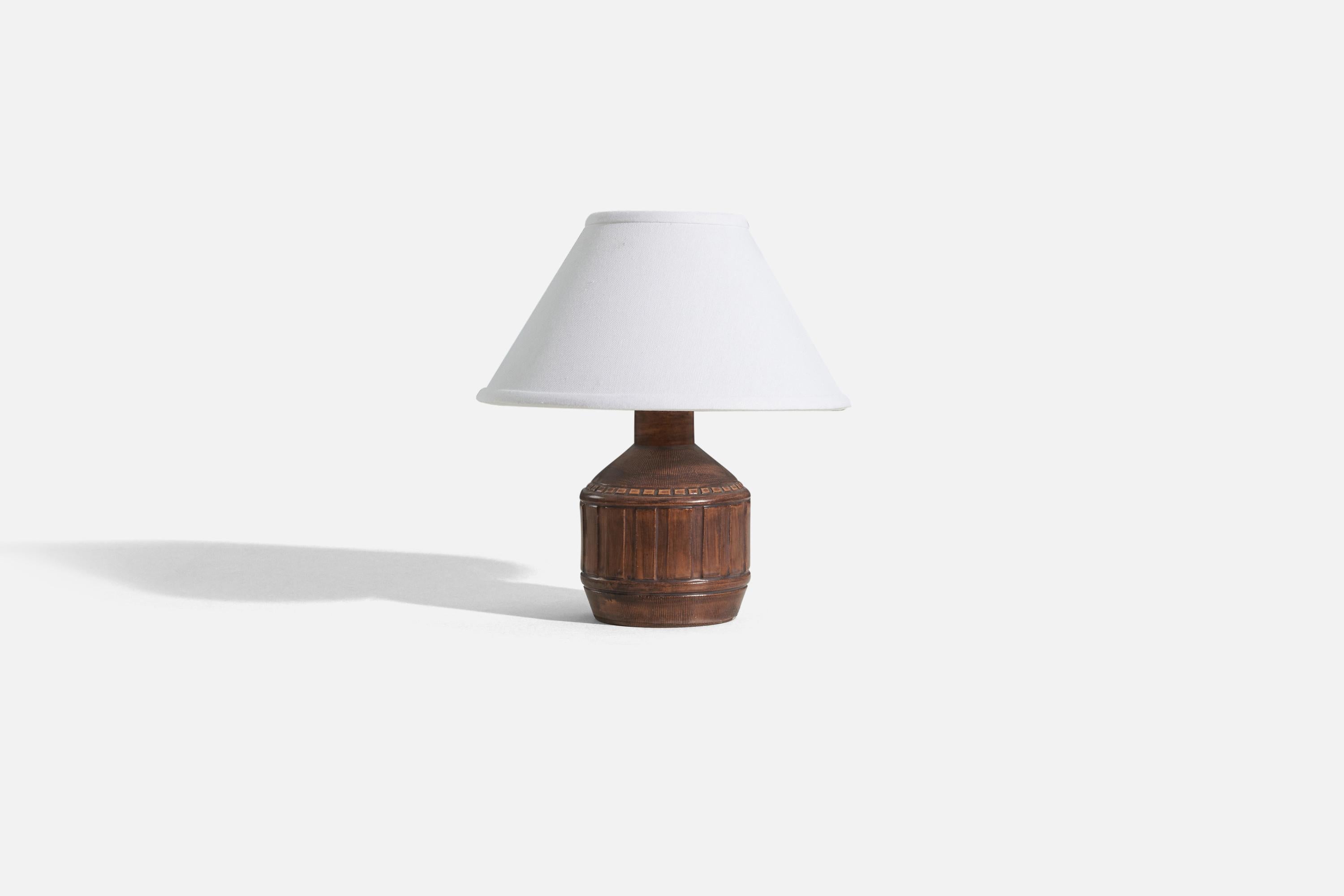 A brown, stoneware table lamp designed and produced in Sweden, c. 1960s. 

Sold without lampshade. 
Dimensions of Lamp (inches) : 8.25 x 4.5 x 4.5 (H x W x D)
Dimensions of Shade (inches) : 4.5 x 10.25 x 6 (T x B x H)
Dimension of Lamp with Shade