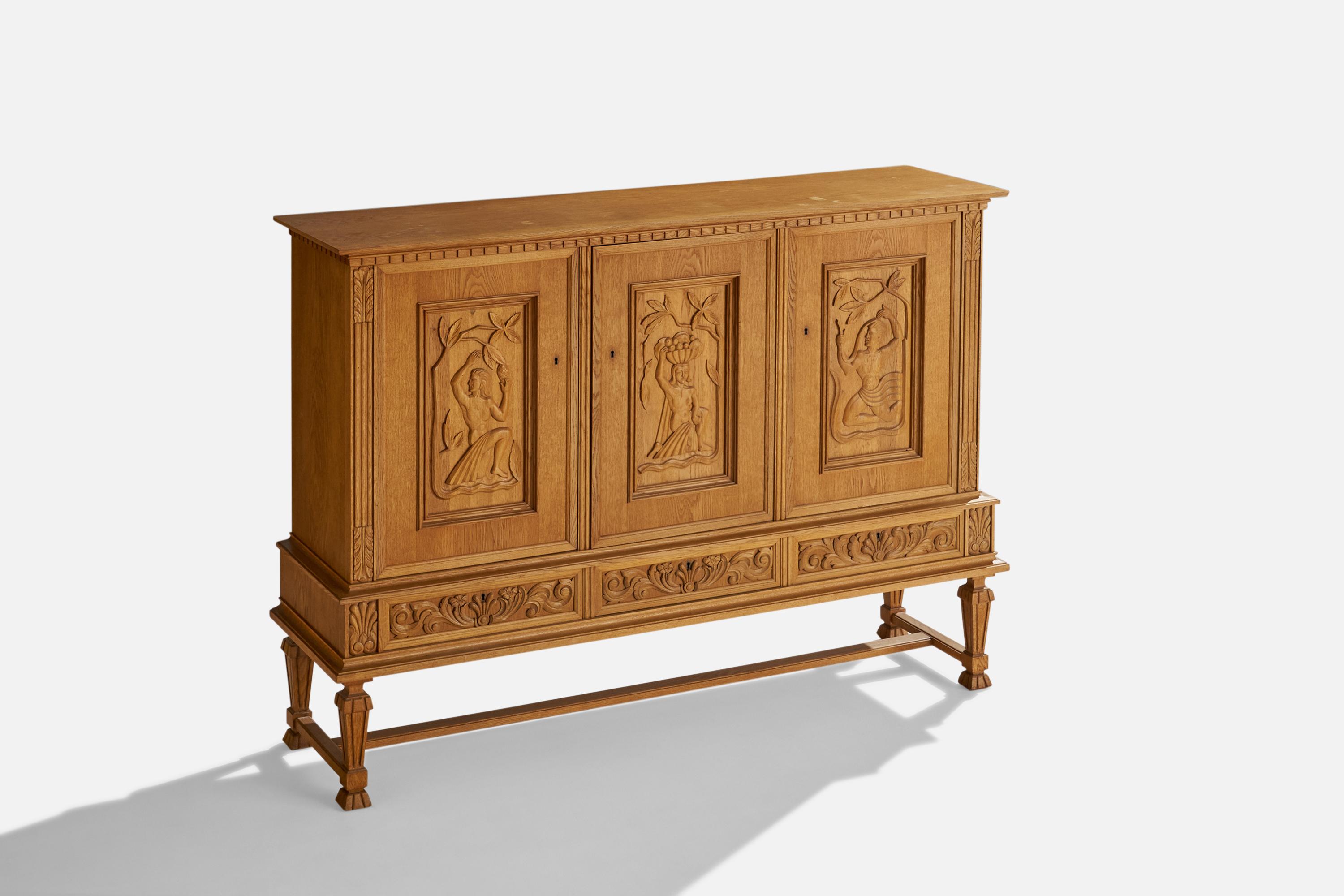 An oak cabinet with hand-carved details designed and produced in Sweden, c. 1920s.