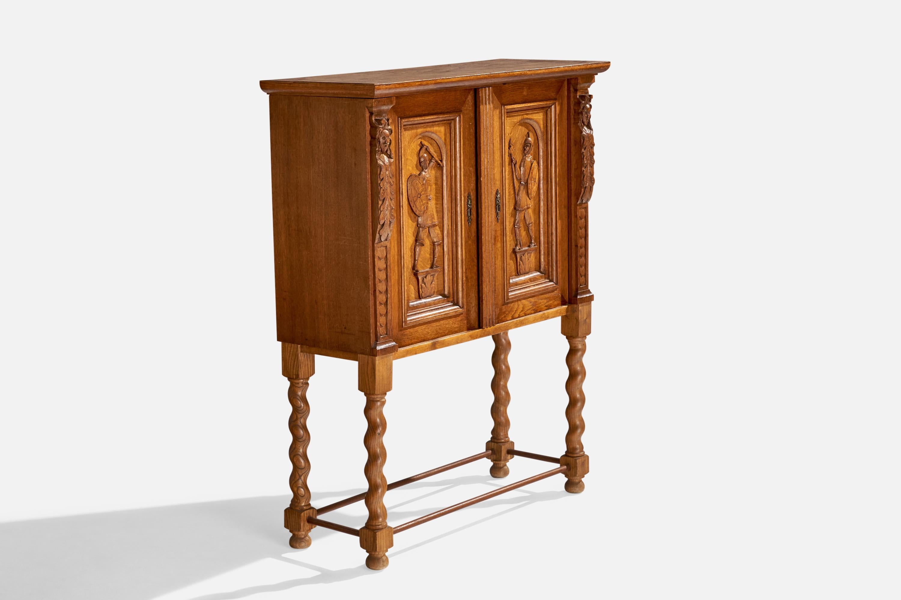 Armadio in legno di quercia intagliato a mano progettato e prodotto in Svezia, anni '20 circa.

