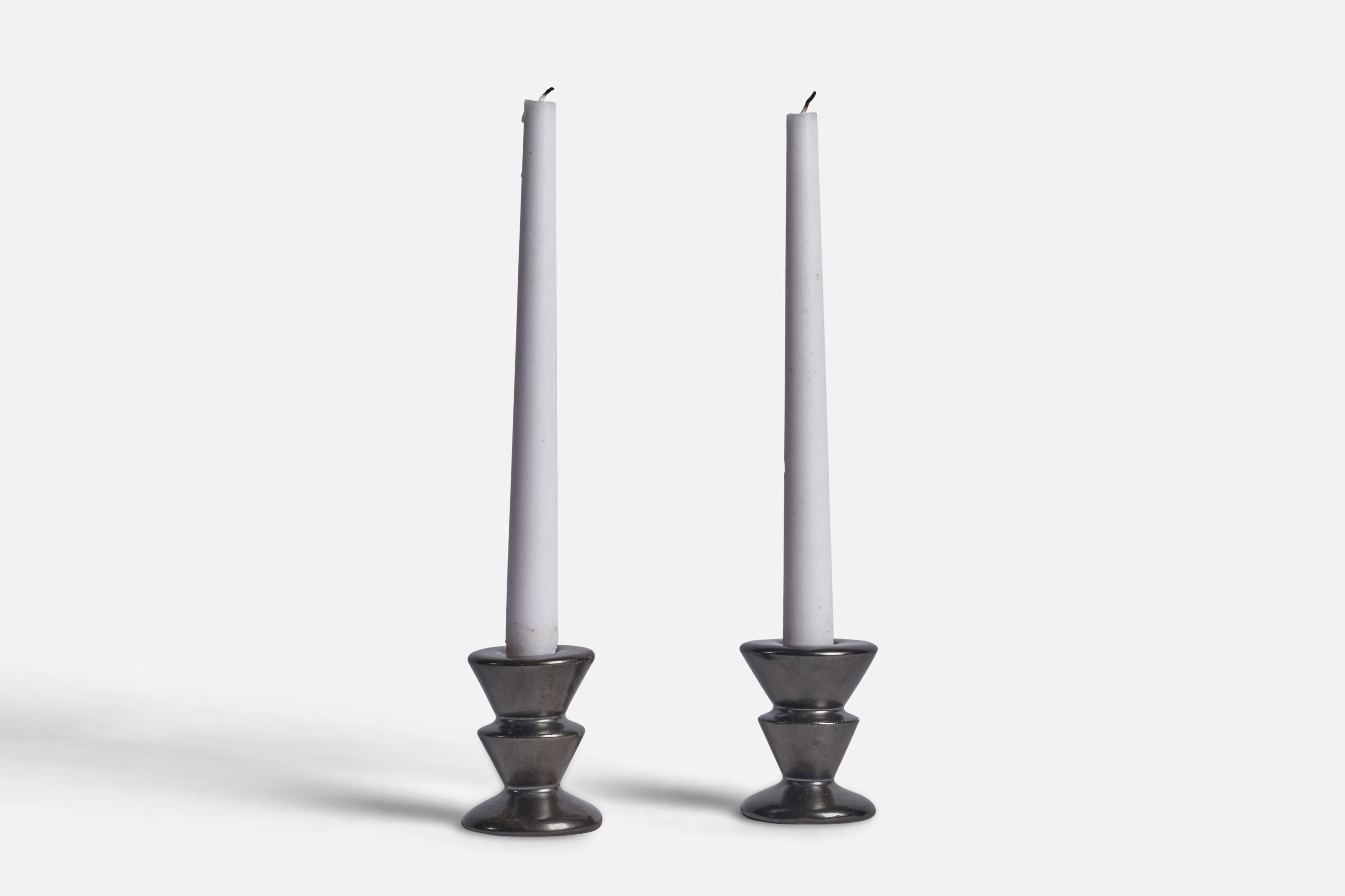 A pair of black-glazed candlesticks designed and produced in Sweden, 1940s.

Fits 0.8” diameter candle