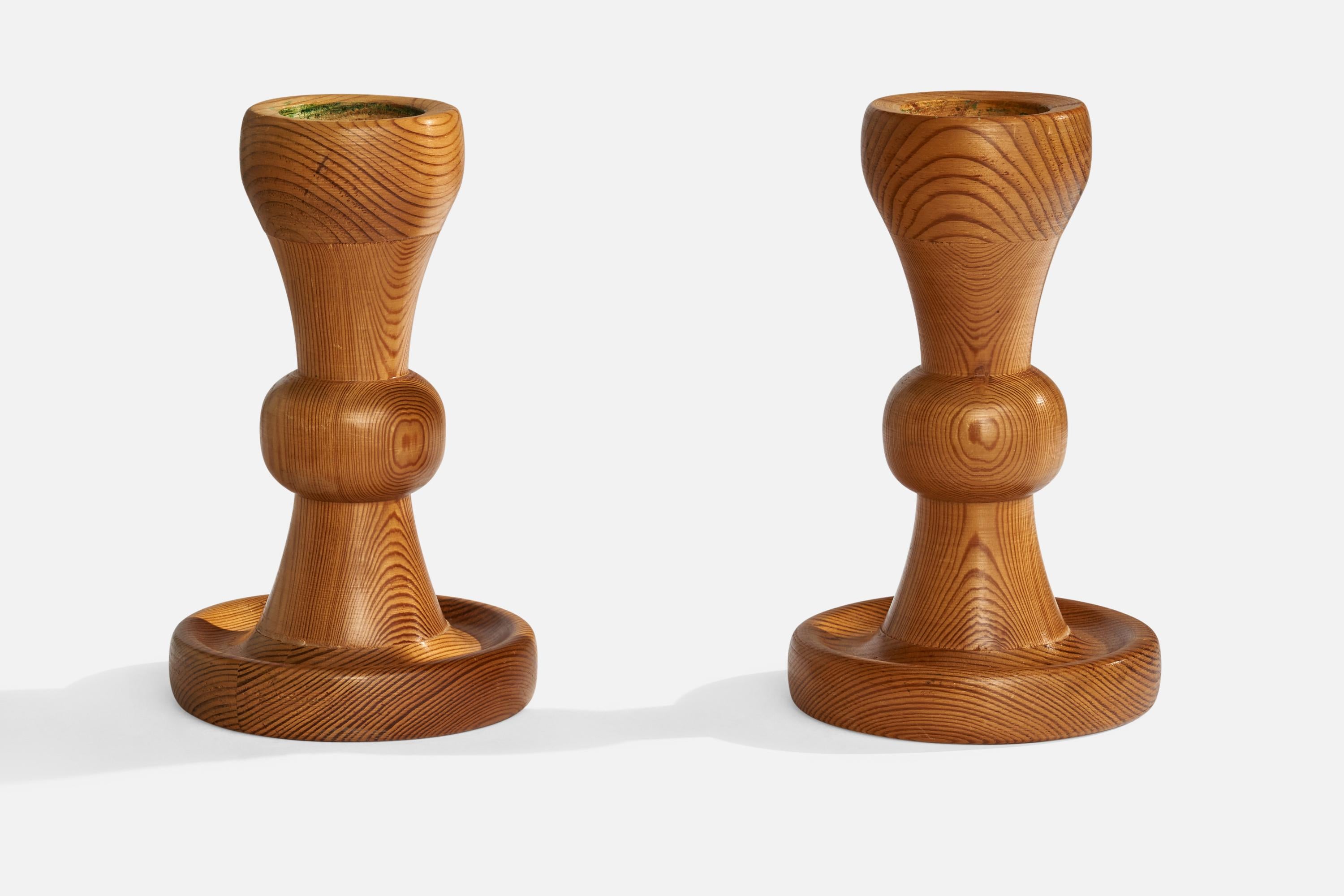 A pair of pine candlesticks designed and produced in Sweden, 1970s.

Holds 2.0” diameter candles