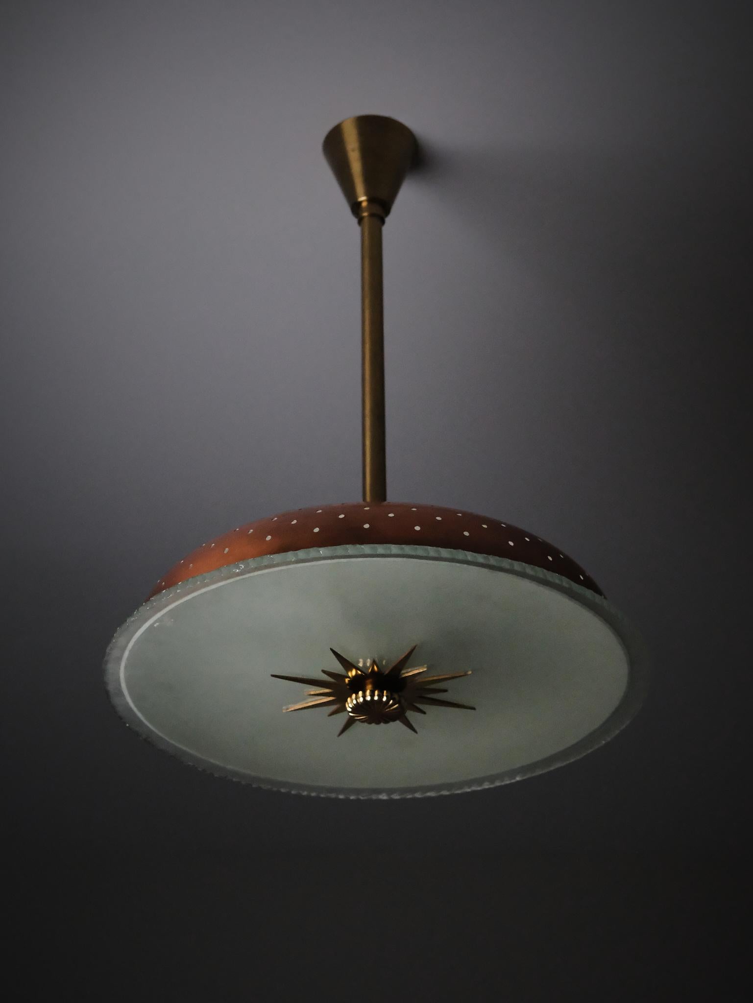 Una distinguida lámpara de techo sueca de la década de 1940, atribuida a un diseñador desconocido. 

Esta pieza, elaborada con cobre, latón y vidrio en bruto, refleja la elegancia discreta y la calidad de fabricación características del diseño