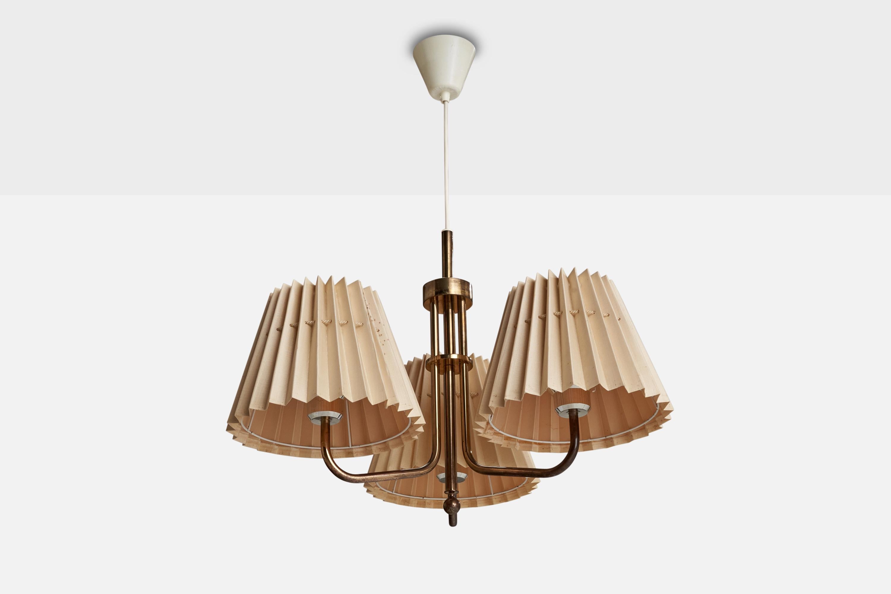 A brass and beige fabric chandelier designed and produced in Sweden, c. 1950s.

Discoloration to lampshades. Study images.
Dimensions of canopy (inches): 3.80” H x 3.44” Diameter
Socket takes standard E-26 bulbs. 3 socket.There is no maximum wattage