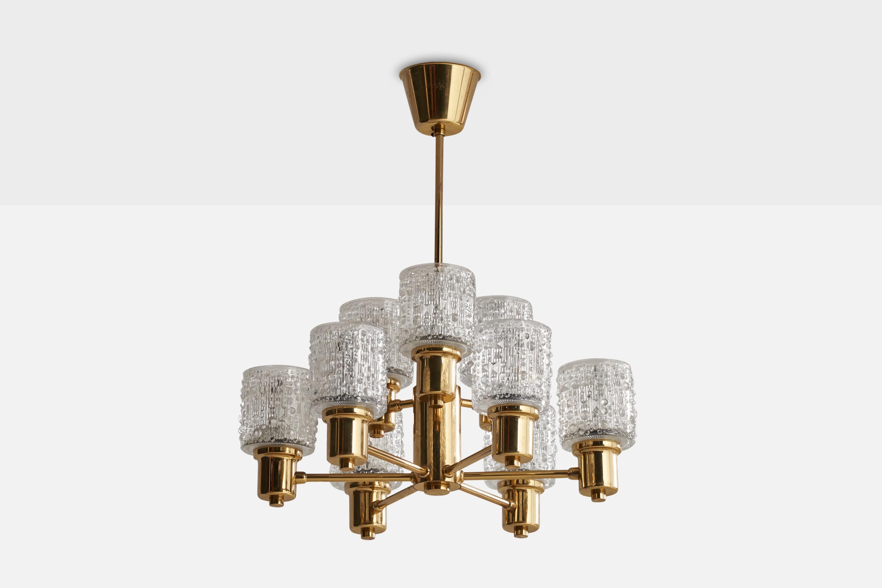 A brass and glass chandelier designed and produced in Sweden, c. 1960s.

Dimensions of canopy (inches): 2.5” H x 3.9” Diameter
Socket takes standard E-14 bulbs. 9 sockets.There is no maximum wattage stated on the fixture. All lighting will be