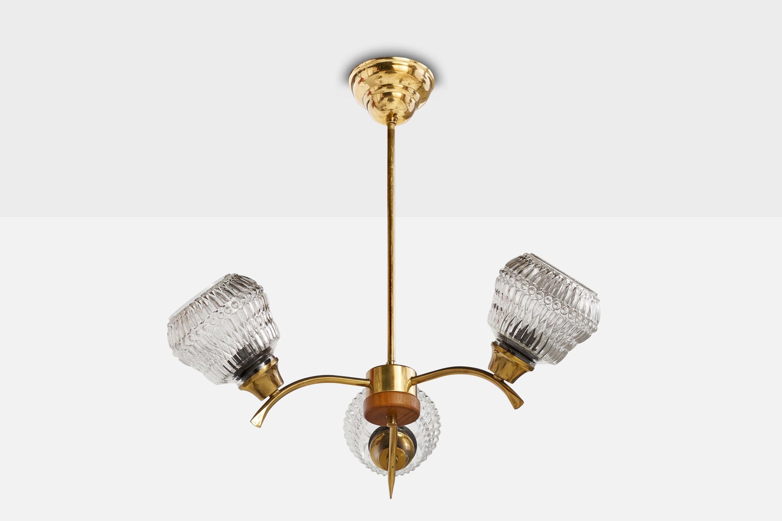 A brass, teak and faceted glass chandelier designed and produced in Sweden, 1950s.

Dimensions of canopy (inches): 2.5” H x 4.25”  Diameter
Socket takes standard E-26 bulbs. 3 sockets.There is no maximum wattage stated on the fixture. All lighting