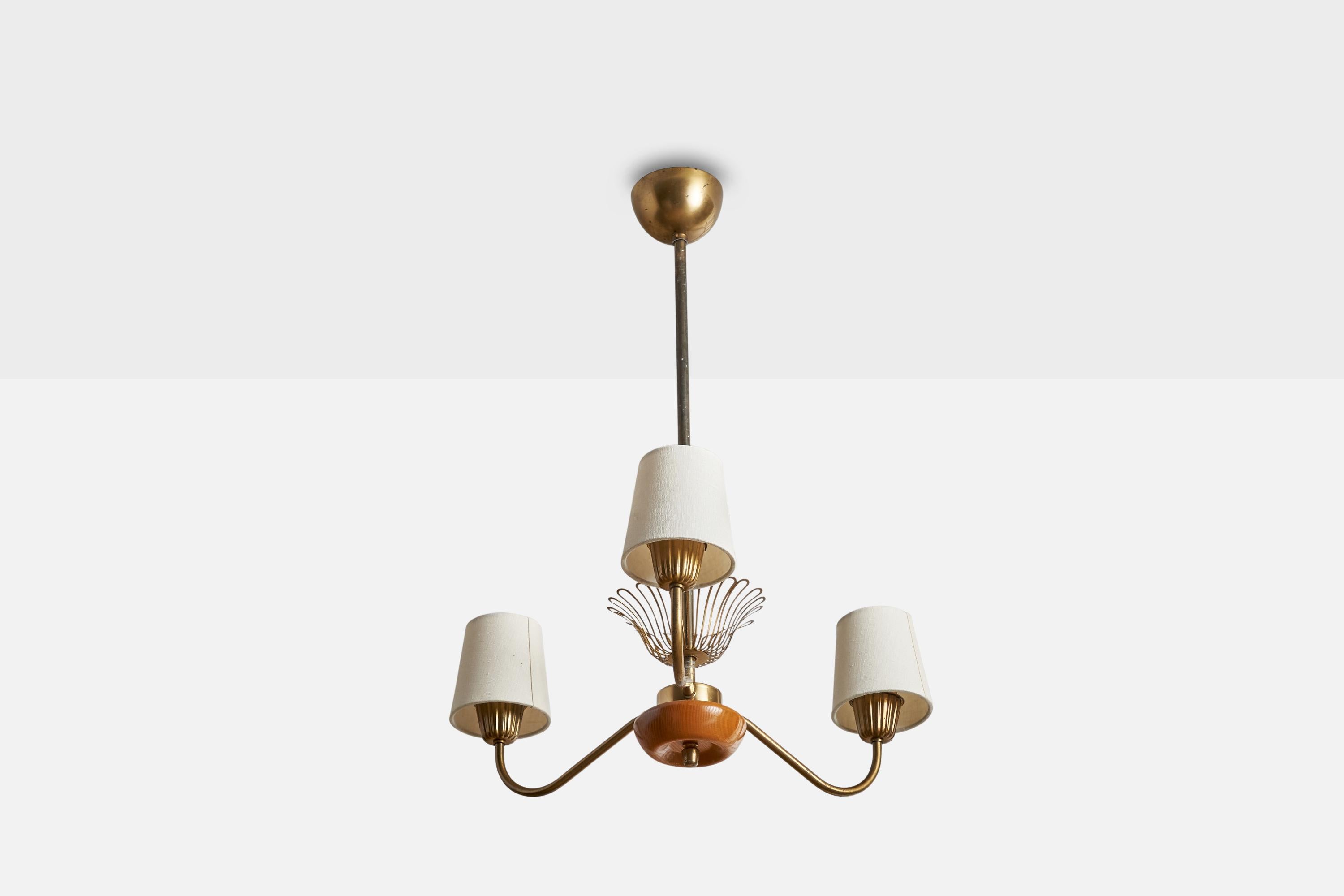 A brass, oak and white fabric chandelier designed and produced in Sweden, 1940s.

Dimensions of canopy (inches): 2.5” H x 4” Diameter
Socket takes standard E-26 bulbs. 3 sockets.There is no maximum wattage stated on the fixture. All lighting will be