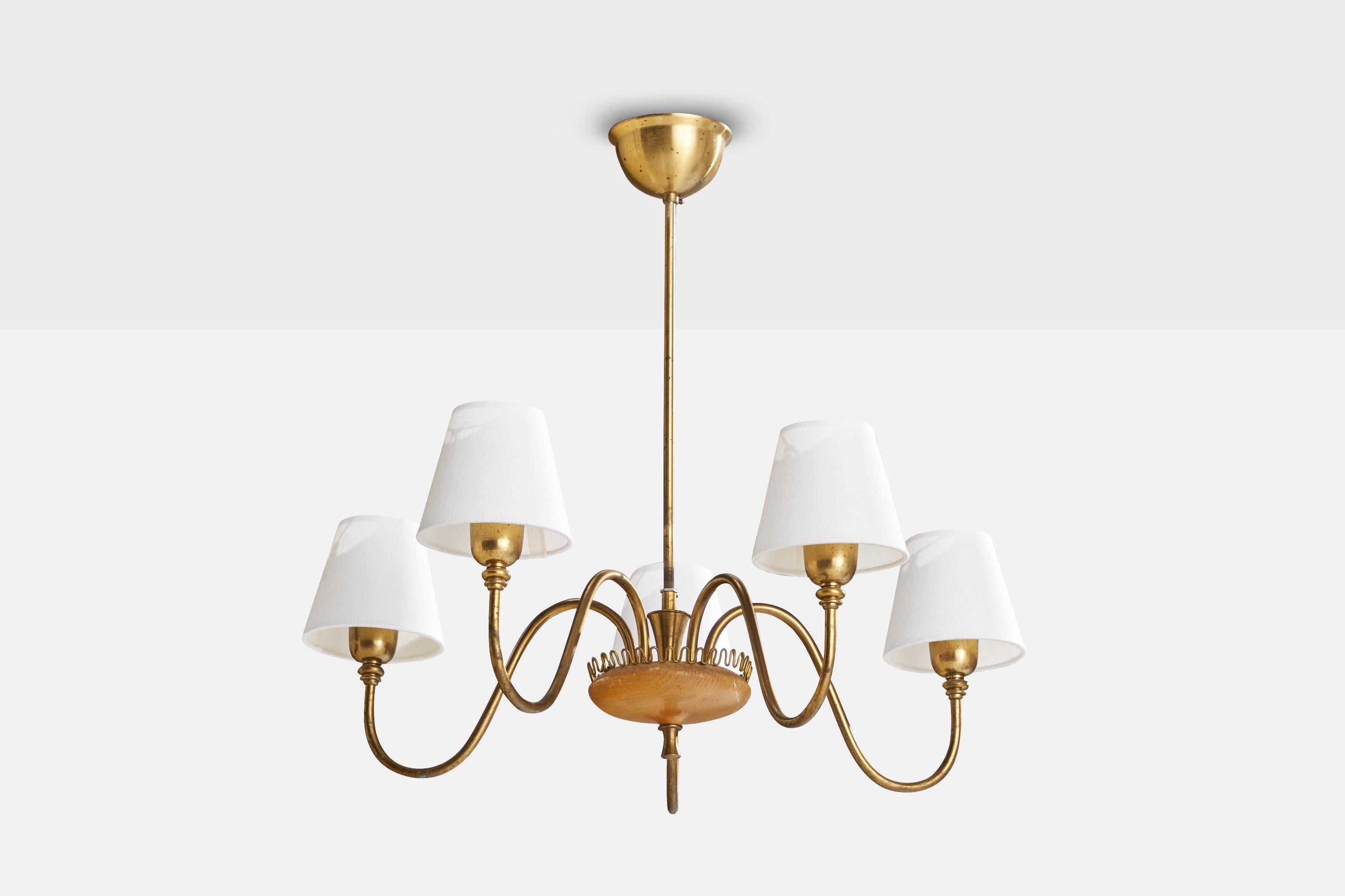 A brass, oak and white fabric chandelier designed and produced in Sweden, 1940s.

Dimensions of canopy (inches): 2.5”  H x 4.5” Diameter
Socket takes standard E-26 bulbs. 5 sockets.There is no maximum wattage stated on the fixture. All lighting will