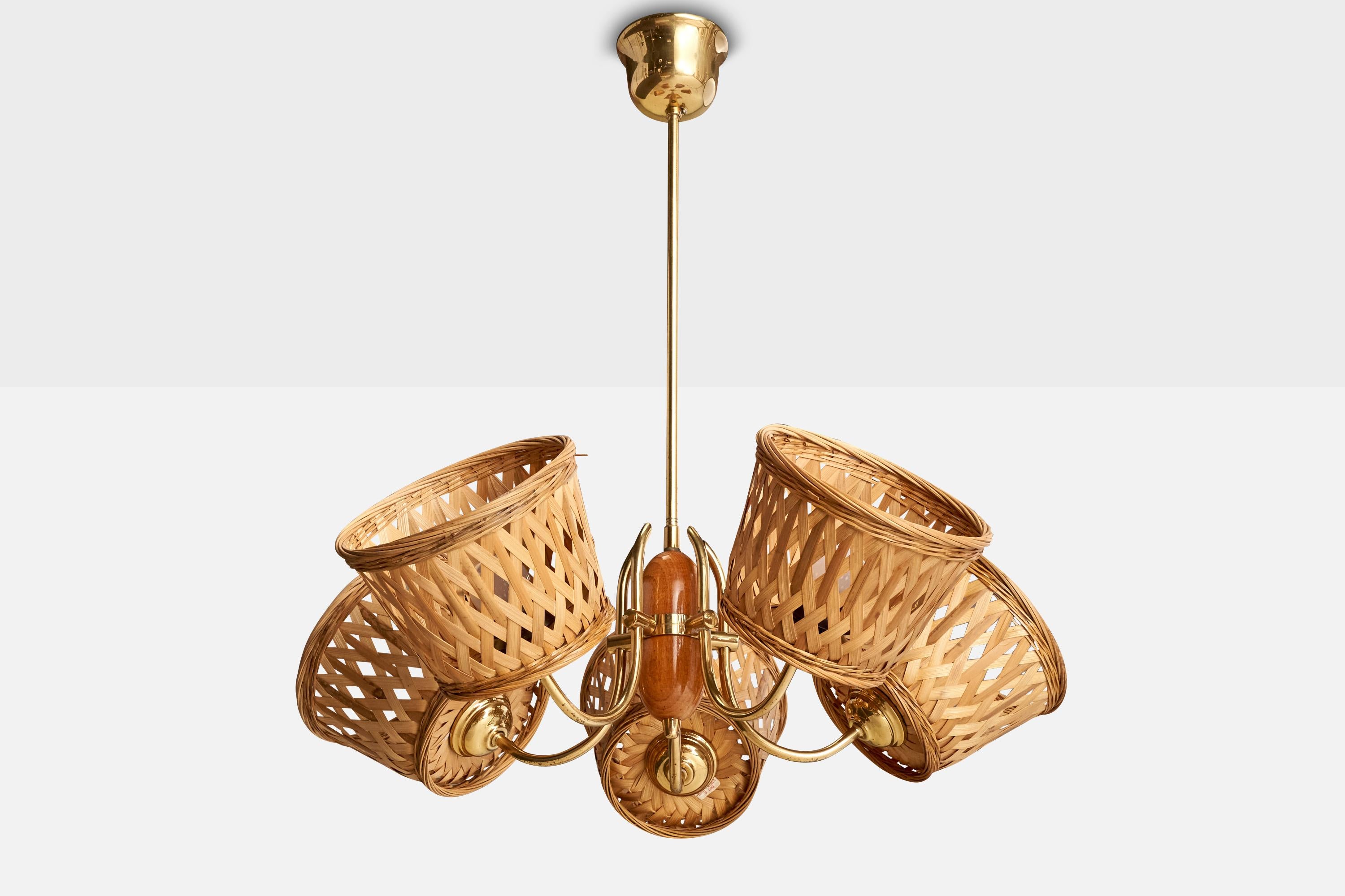 A brass, oak and rattan chandelier designed and produced in Sweden, c. 1950s.

Assorted rattan lampshades.
Overall Dimensions (inches): 25.5” H x 23.375 ” Diameter
Dimensions of Canopy:  3.375” H x 3.875” W x 3.875” D
Stem length: 15.875”H
Bulb
