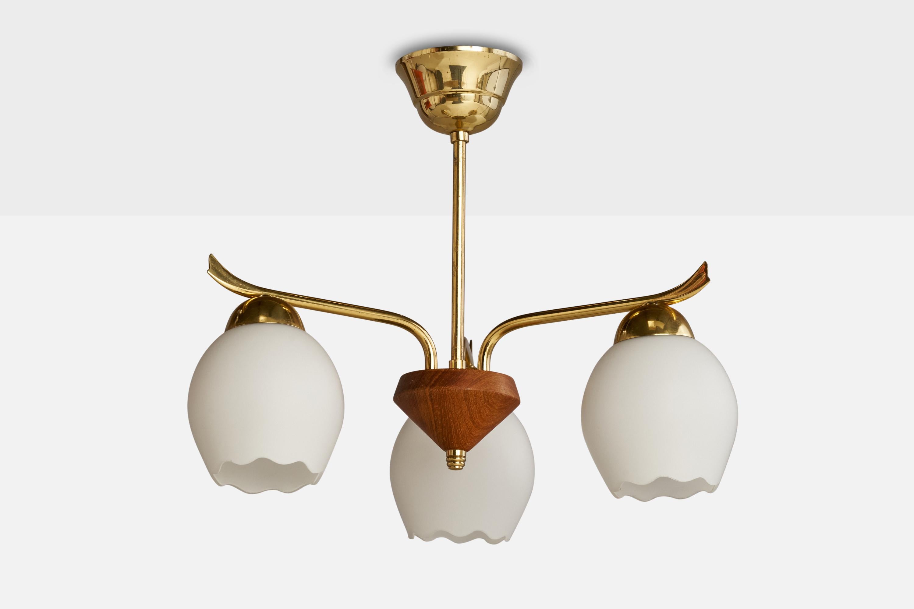A brass teak and glass chandelier light designed and produced in Sweden, 1950s.

Dimensions of canopy (inches): 2.5” H x 3.75” Diameter
Socket takes standard E-26 bulbs. 3 sockets.There is no maximum wattage stated on the fixture. All lighting will