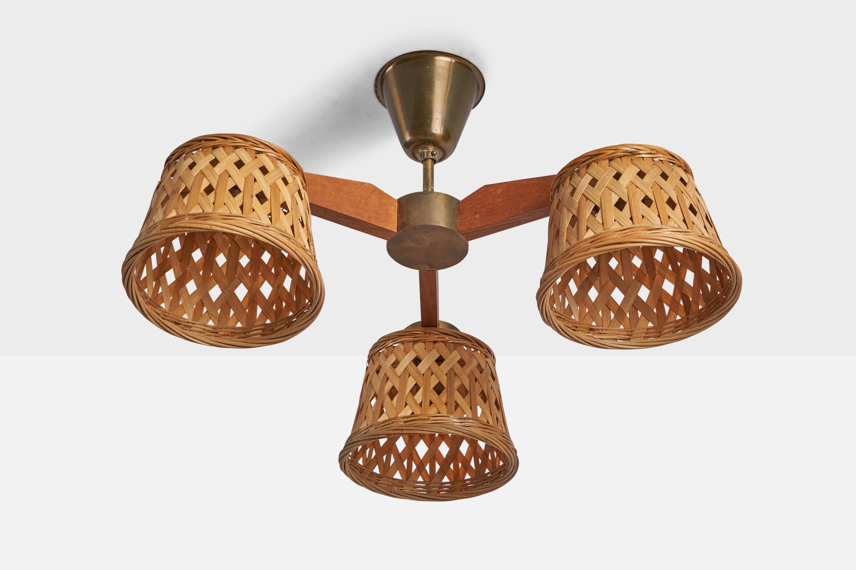 A three-armed brass, teak and rattan chandelier designed and produced in Sweden, c. 1950s.

Overall Dimensions (inches): 10.75” H x 18” Diameter
Bulb Specifications: E-14 Bulb
Number of Sockets: 3
Assorted vintage rattan lampshades.
