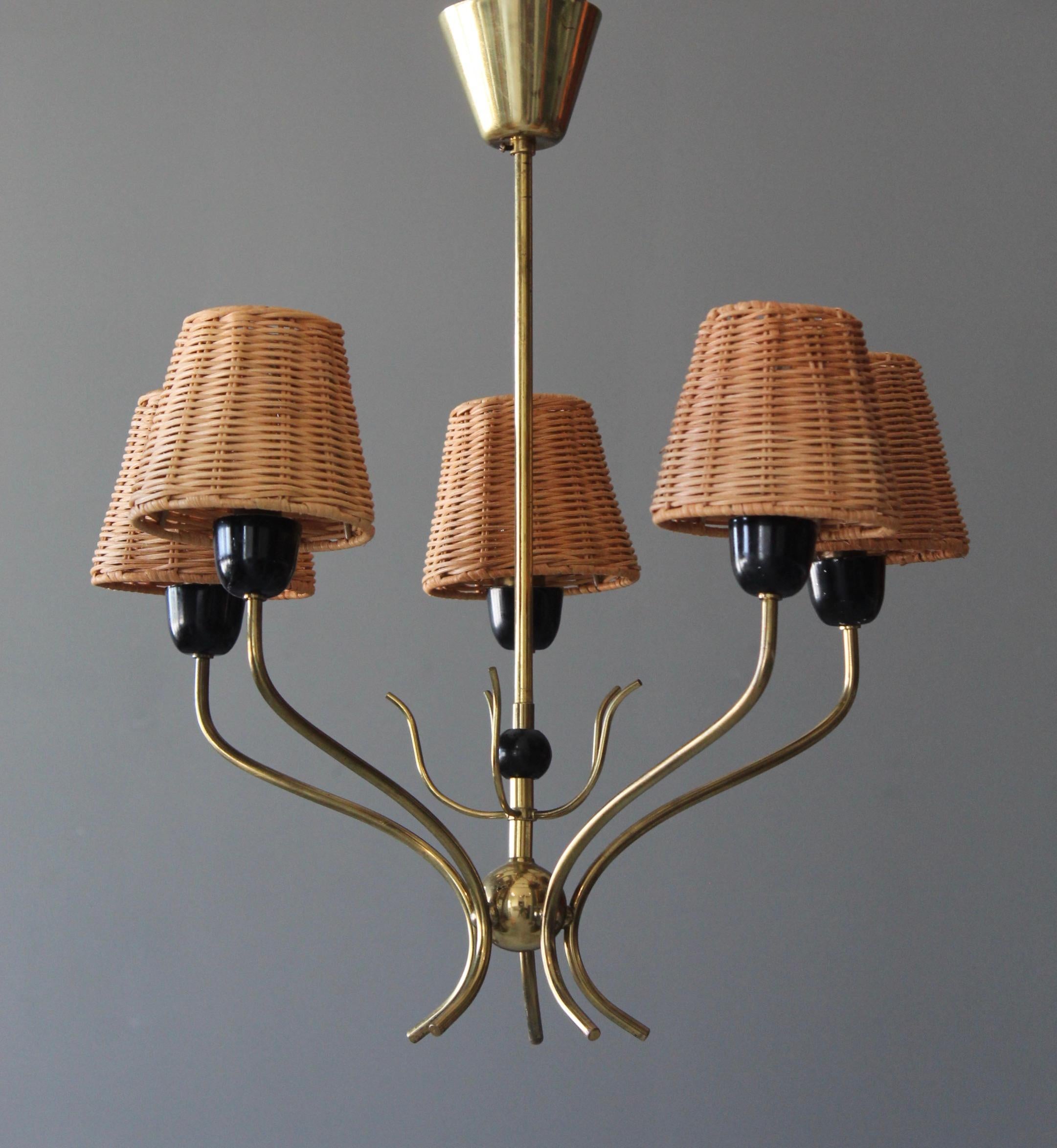 A chandelier, designed and producec in Sweden. c. 1950s. Assorted rattan lampshades are out of stock and currently not included in purchase. Diameter measured with lampshades. 

Features brass, lacquered metal. 

Other designers include Jean Royère,