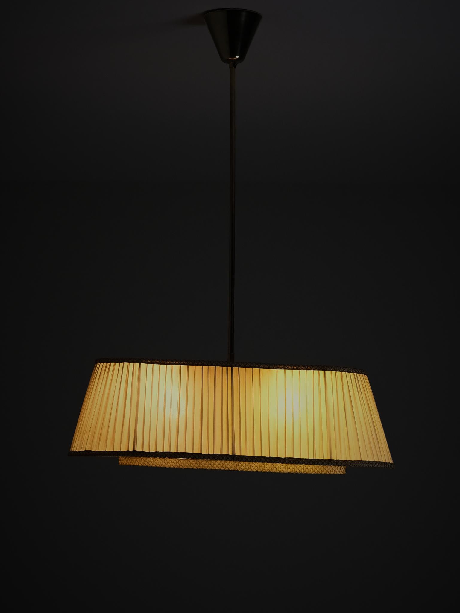 Beautiful ceiling light by unknown Swedish designer during the first half of the 20th century. 

Elegant design in brass and fabric. Two light sources. 