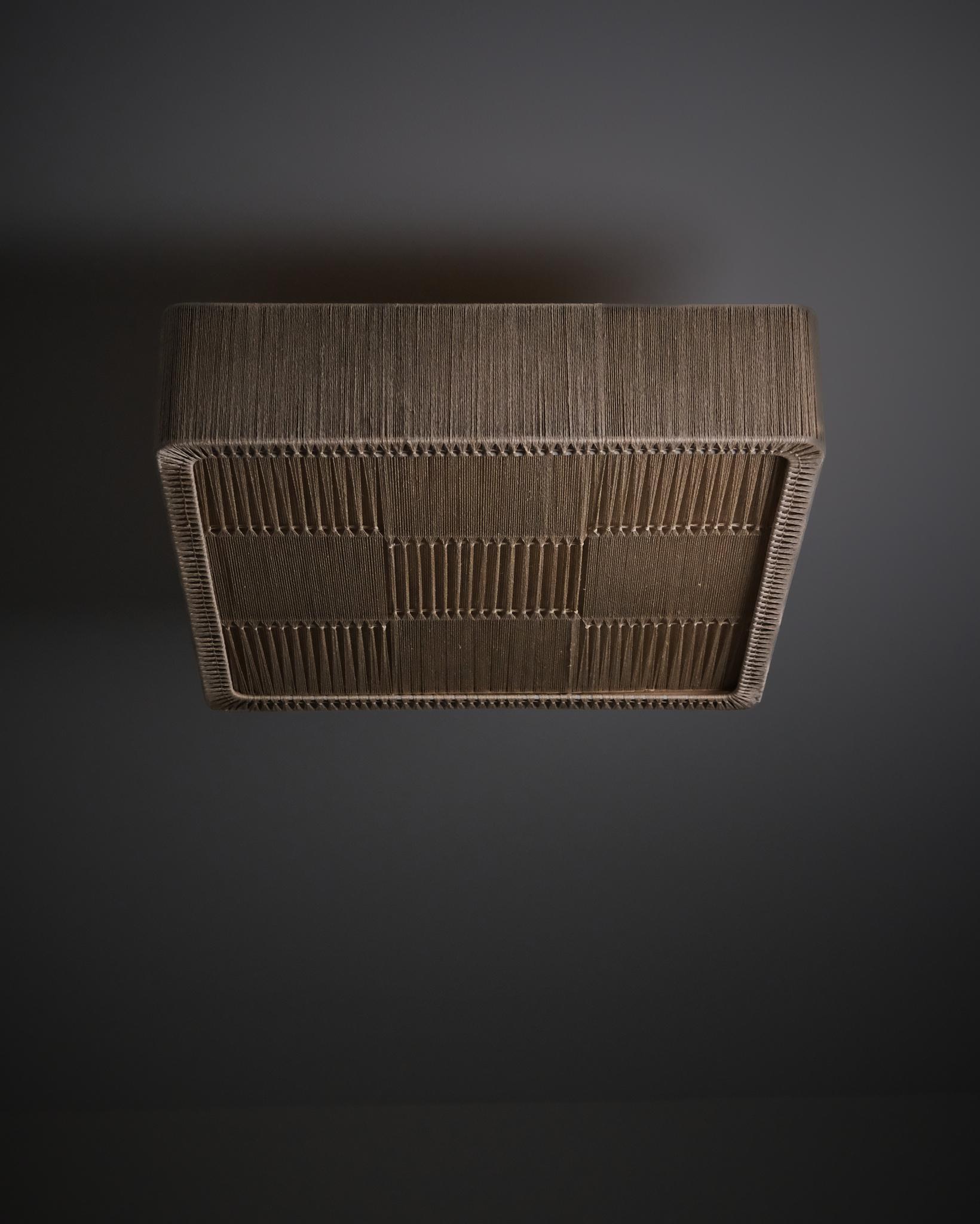 Elegant ceiling light made in Sweden during the 1960s.

Crafted with a beige fabric cord stretched over a steel frame, this piece combines Scandinavian simplicity with subtle texture. Its square form and natural tones create a warm light, perfect