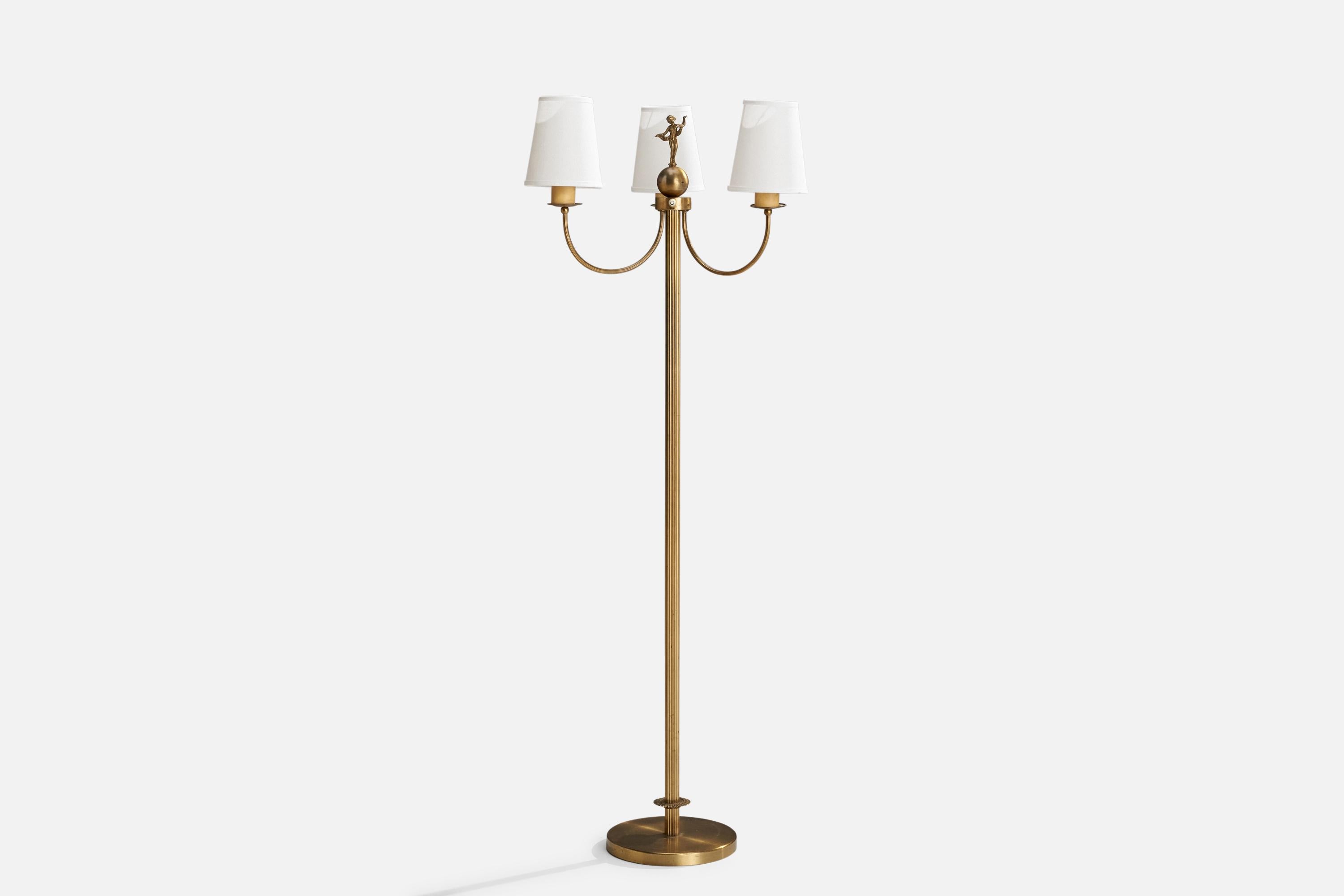 A brass, bakelite and white fabric floor lamp designed and produced in Sweden.

Overall Dimensions (inches): 60.5” H x 20.5” W x 17” D
Stated dimensions include shade.
Bulb Specifications: E-26 Bulb
Number of Sockets: 3
All lighting will be