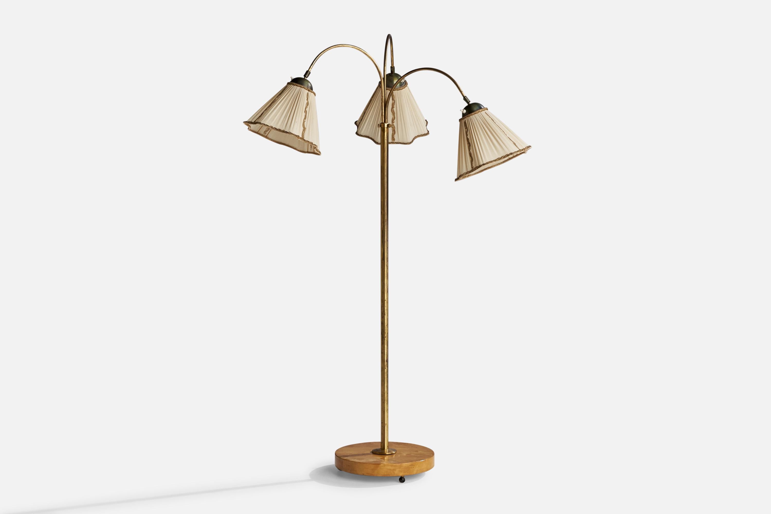 An adjustable three-armed brass, off-white fabric and birch floor lamp designed and produced in Sweden, 1940s.

Dimensions variable.
Overall Dimensions (inches): 59.25”  H x 42” W x 28”  D
Stated dimensions include shade.
Bulb Specifications: E-26
