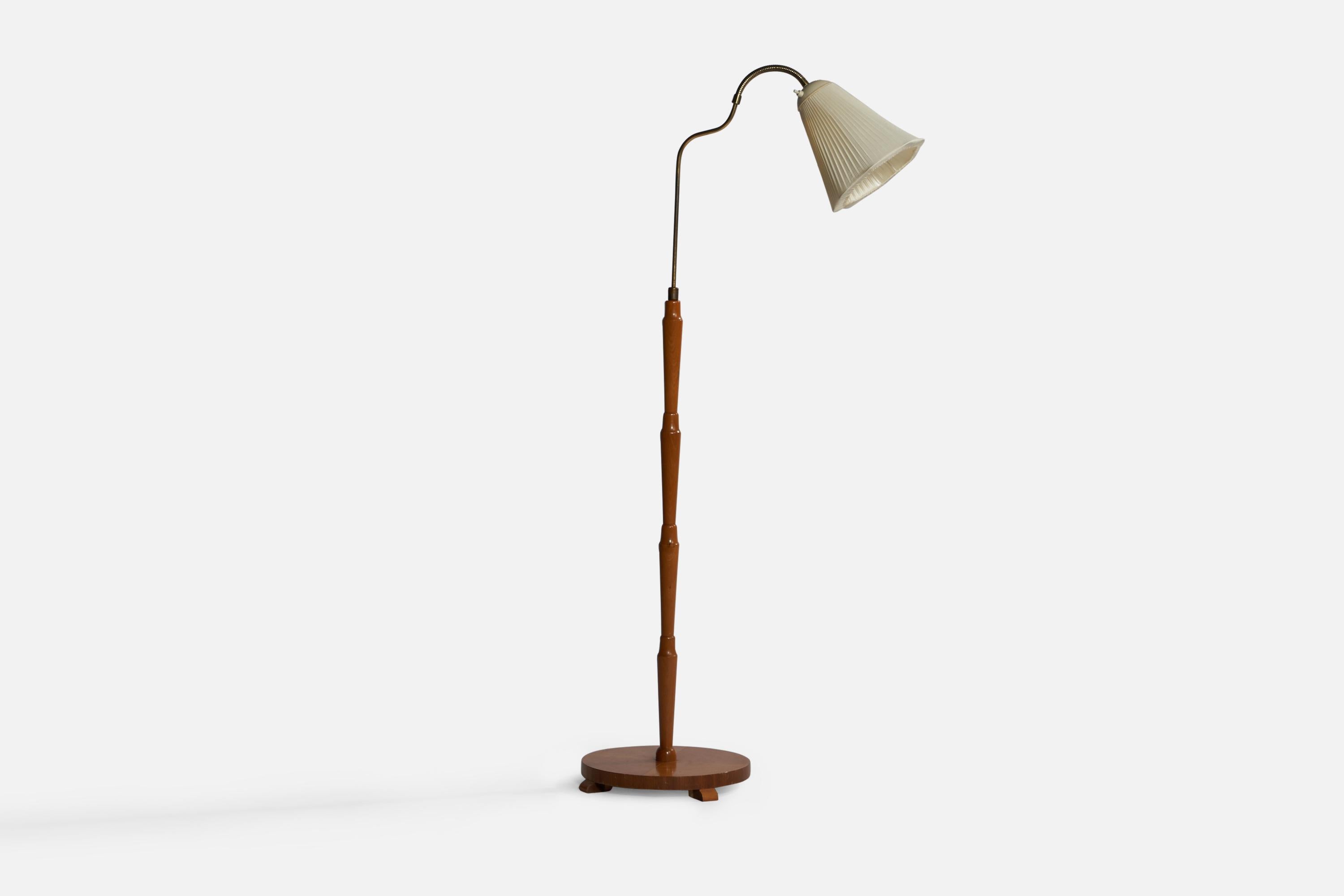 An adjustable organic brass, stained elm and off-white fabric floor lamp designed and produced in Sweden, 1930s.

Overall Dimensions (inches): 59” H x 13.75” W x 27.25” D. Stated dimensions include shade.
Dimensions vary based on position of
