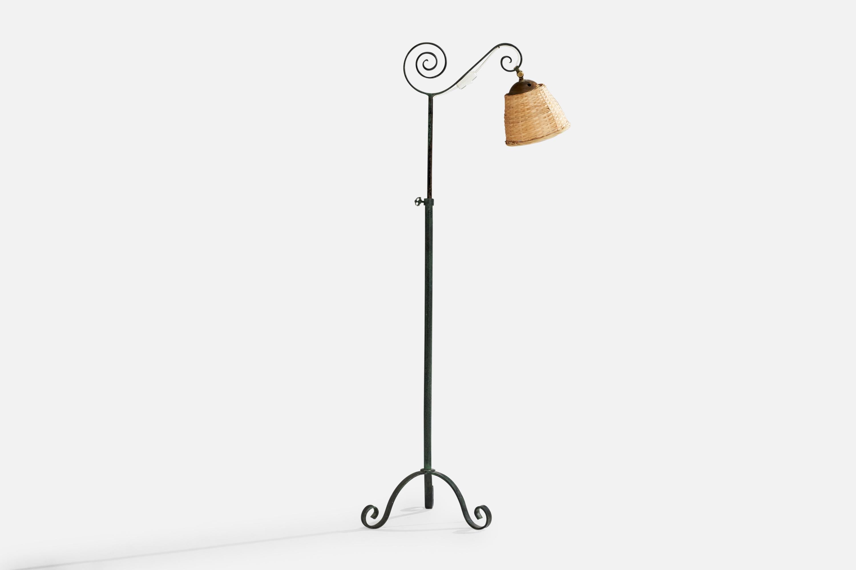 Lampadaire en fer peint en vert et en noir, en laiton et en rotin, conçu et produit en Suède, vers les années 1940.

Dimensions de la lampe avec abat-jour (pouces) : 50.6