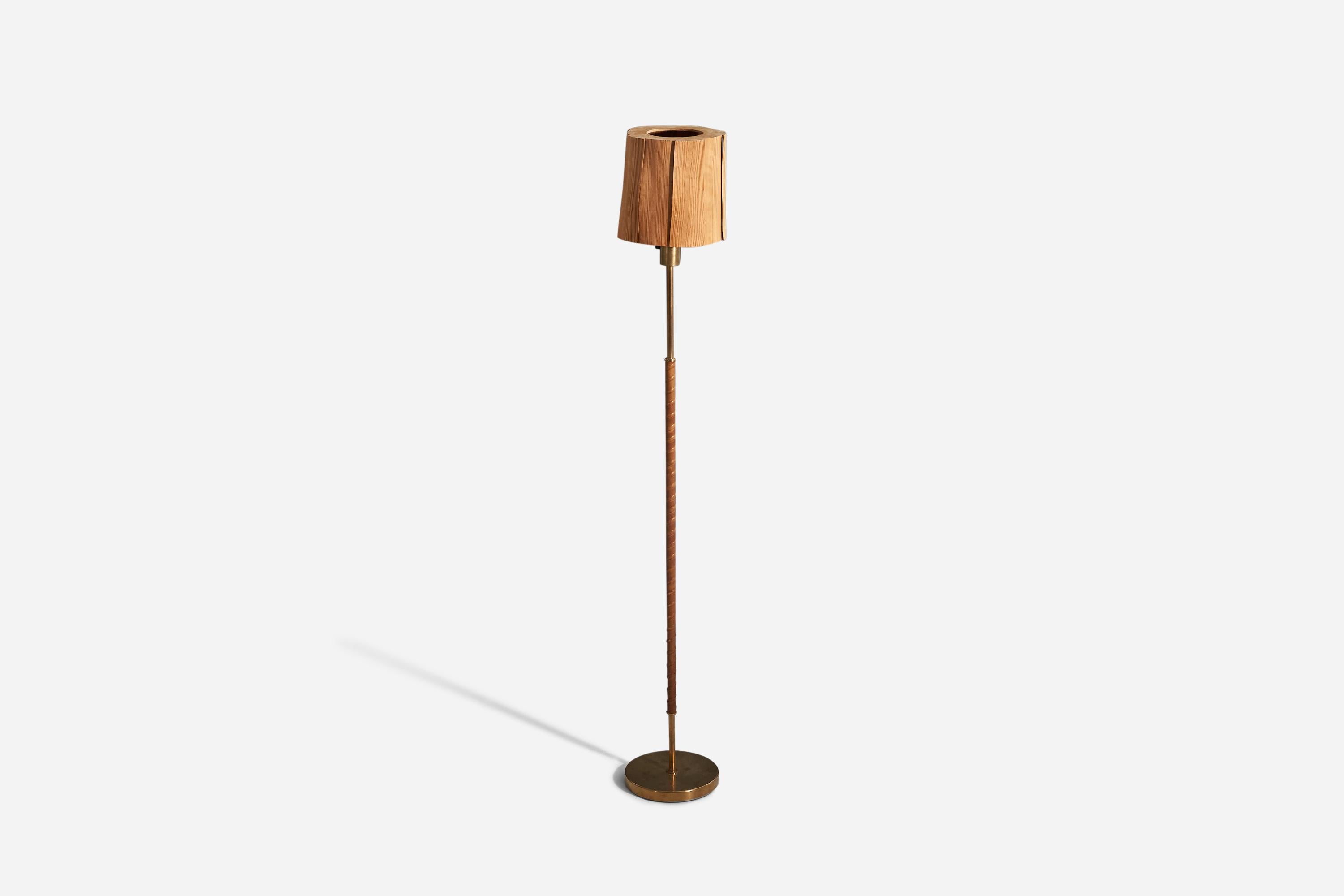 A brass, leather and pine floor lamp designed and produced by a Swedish designer, Sweden, 1940s. 

Sold with lampshade. 
Dimensions stated refer to the floor lamp with the shade.
 