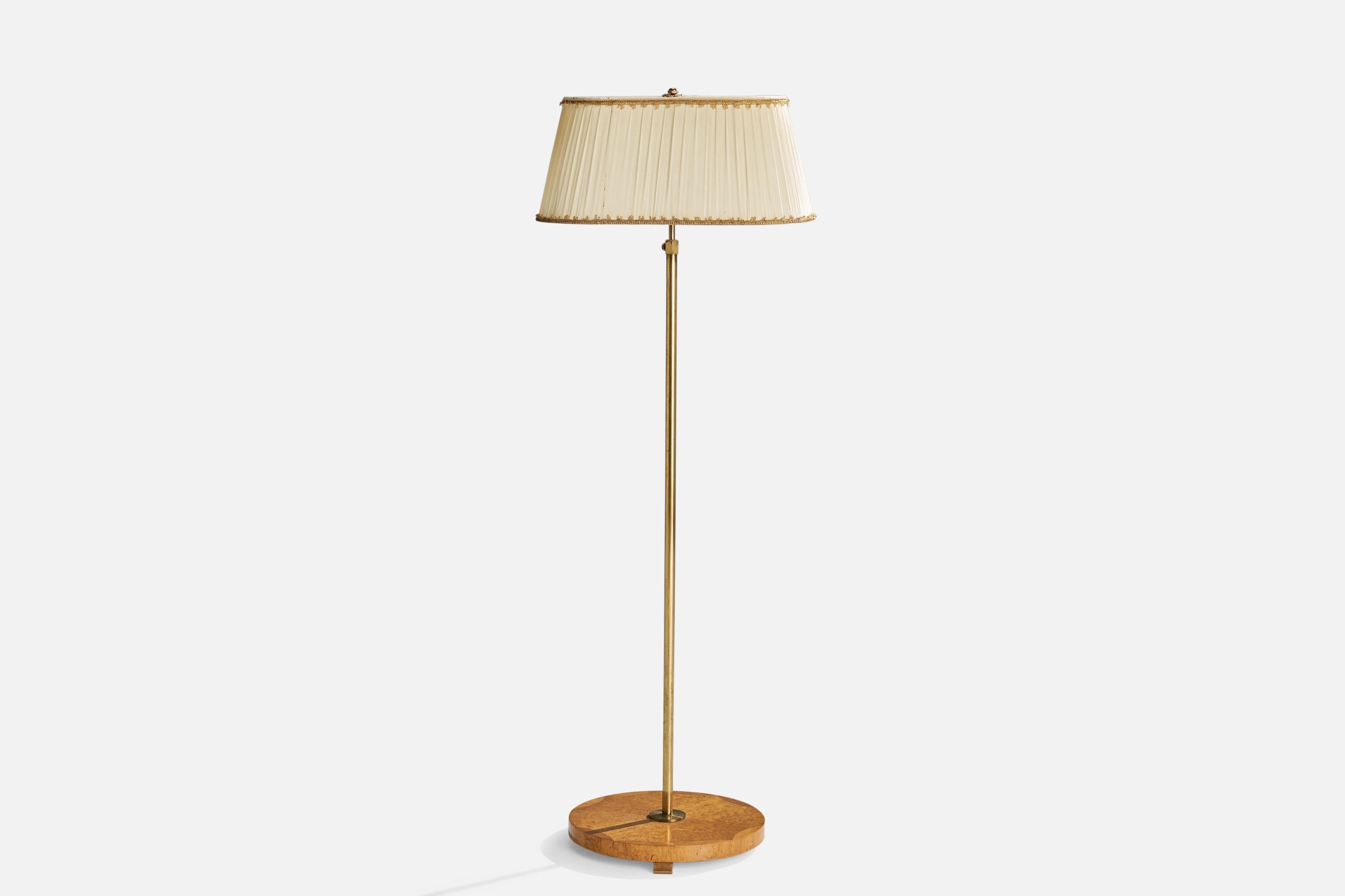 An adjustable brass, masur birch and off-white fabric floor lamp designed and produced in Sweden, 1930s.

Vintage lampshade in fair condition.
Overall Dimensions (inches): 73.23” H x 21.66”  W x 15.75” D
Stated dimensions include shade.
Bulb