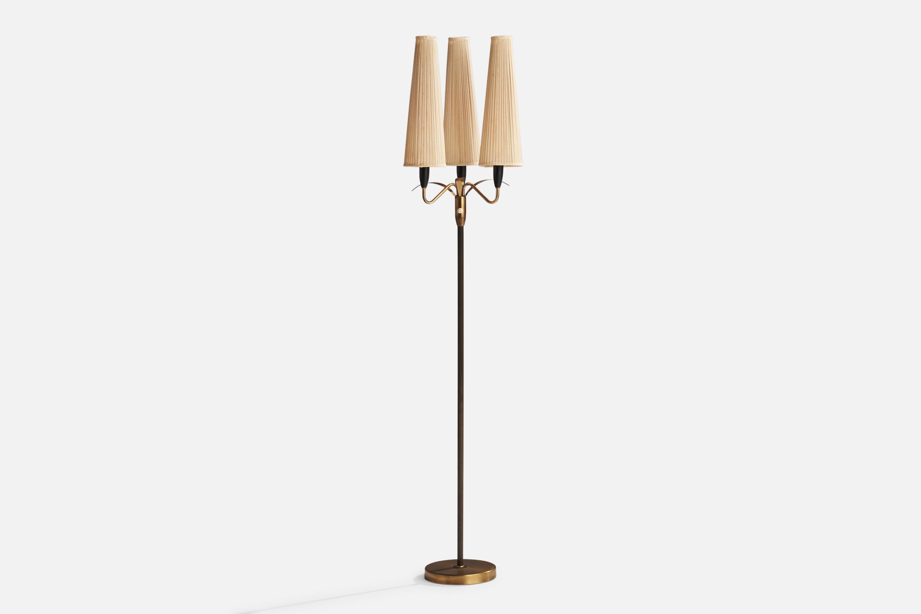 A three-armed brass, black-lacquered metal and beige fabric floor lamp designed and produced in Sweden, 1950s.

Overall Dimensions (inches): 67” H x 13.5”  W x 14” D
Stated dimensions include shade.
Bulb Specifications: E-14 Bulb
Number of Sockets: