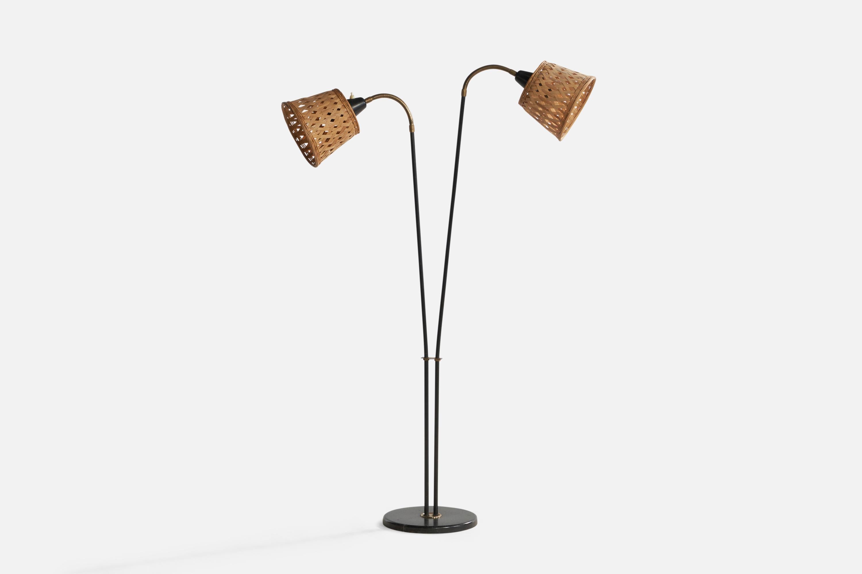 An adjustable two-armed brass, black-lacquered metal and rattan floor lamp designed and produced in Sweden, 1950s.

Overall Dimensions (inches): 60.5” H x 32” W x 10.3” Depth. Stated dimensions include shades.
Dimensions vary based on position of