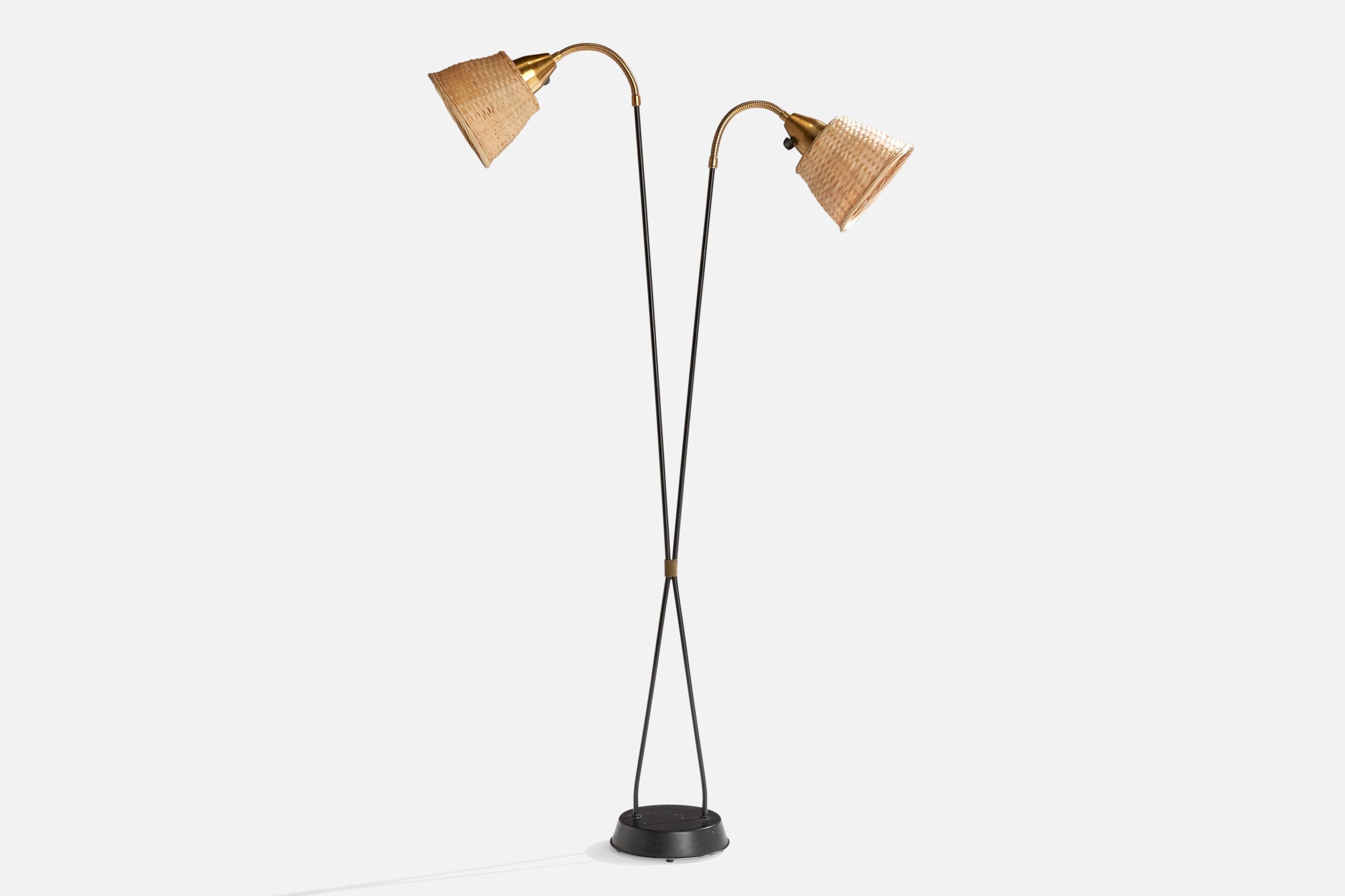 Lampadaire en laiton, métal laqué noir et rotin, conçu et produit en Suède, vers les années 1950.

Dimensions de la lampe avec abat-jour (pouces) : 53