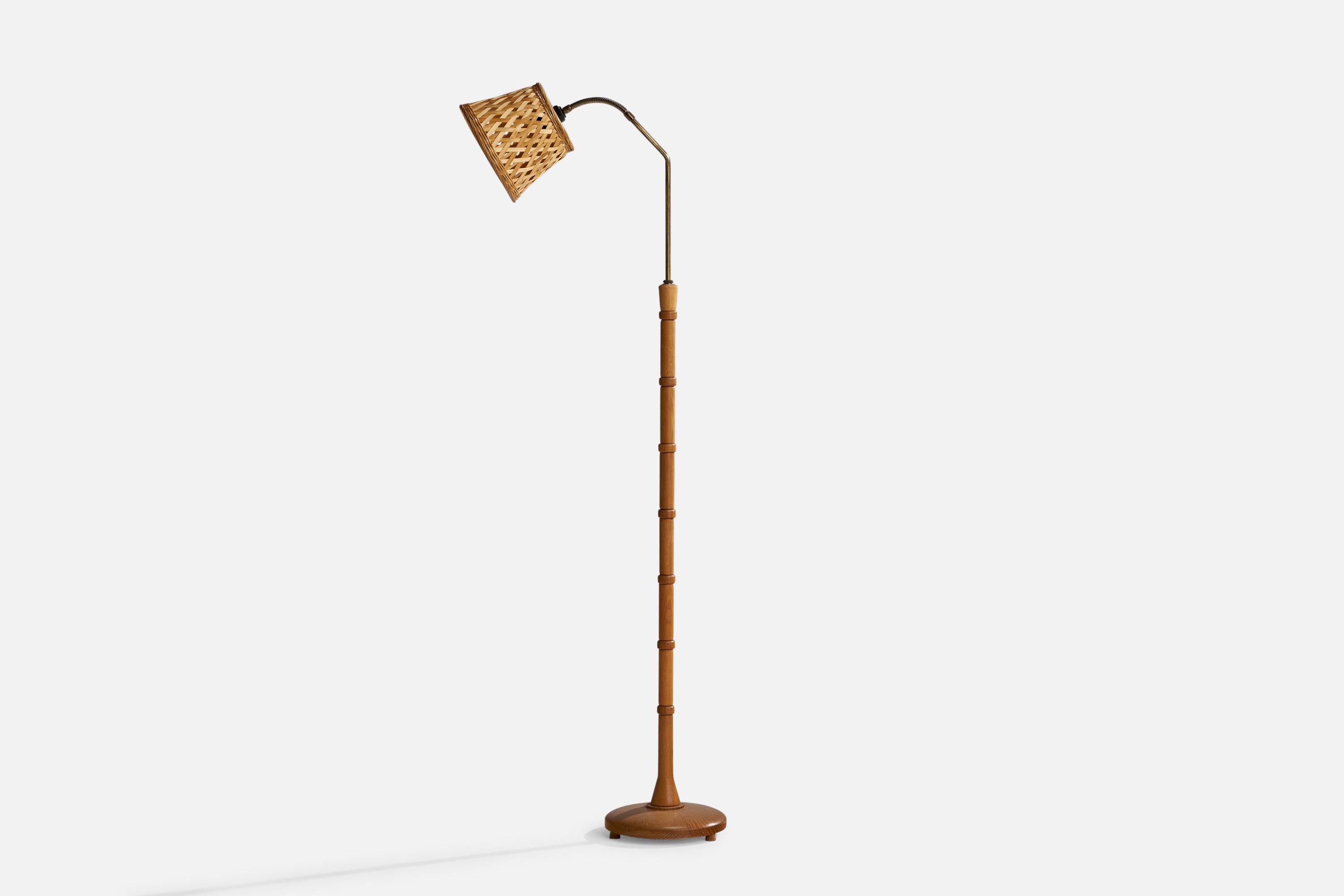 An adjustable oak, brass and rattan floor lamp designed and produced in Sweden, c. 1940s.

Dimensions variable
Overall Dimensions (inches): 52” H x 9.5” W x 19”  D
Stated dimensions include shade.
Bulb Specifications: E-26 Bulb
Number of Sockets: