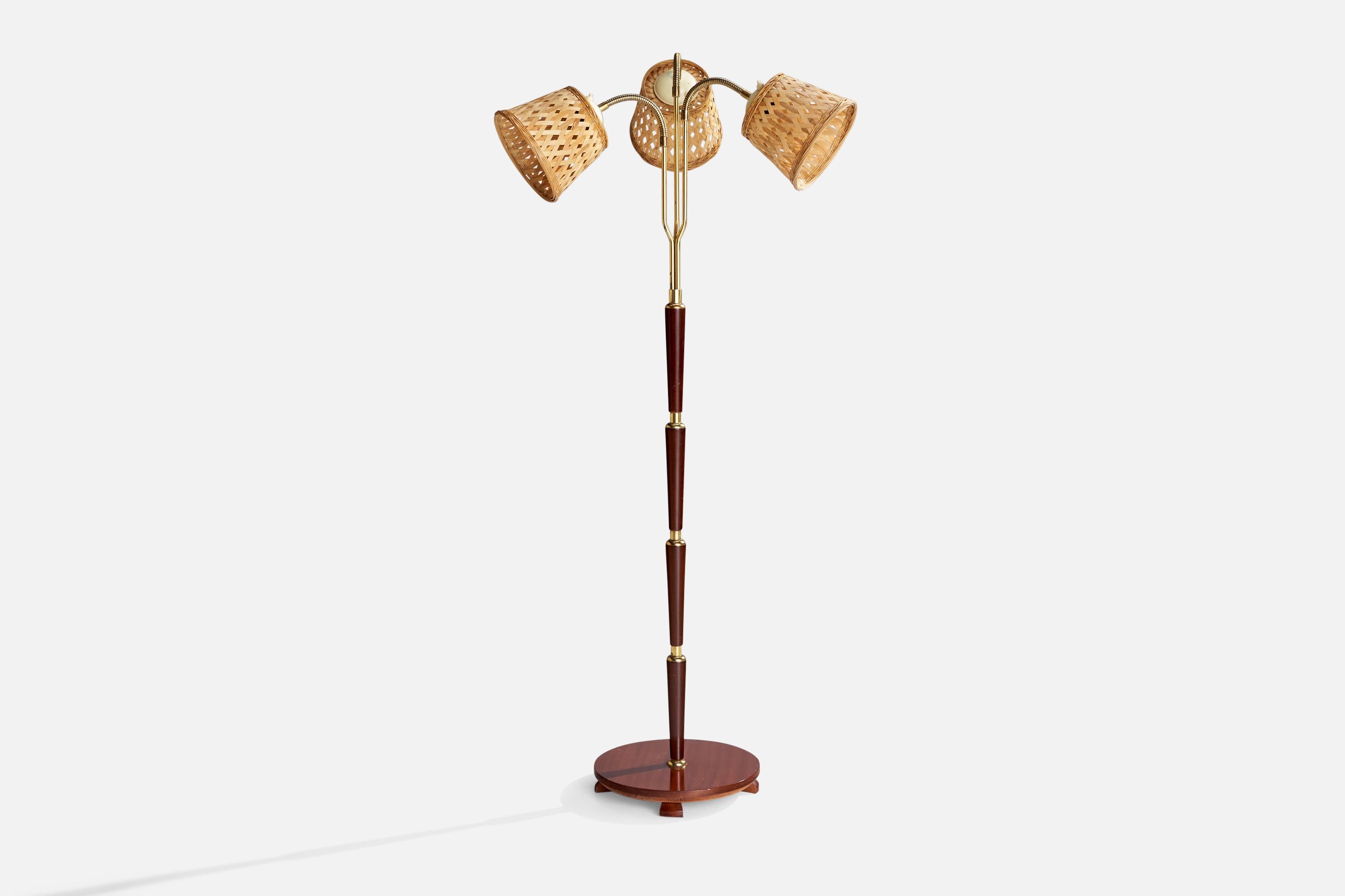 An adjustable three-armed teak, brass and rattan floor lamp designed and produced in Sweden, 1950s.

Overall Dimensions (inches): 63.87” H x 24.5” W x 26.25”  D
Stated dimensions include shade.
Bulb Specifications: E-26 Bulb
Number of Sockets: 3
All
