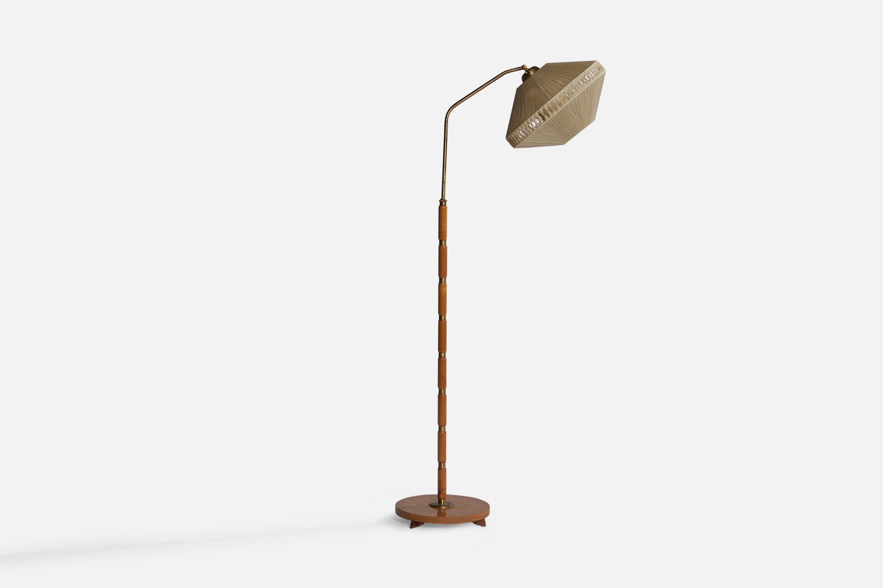 An adjustable brass, wood and string fabric floor lamp designed and produced in Sweden, 1940s.

Overall Dimensions (inches): 63.2” H x 16 ” W x 28” D. Stated dimensions include shade.
Dimensions vary based on position of light.
Bulb Specifications: