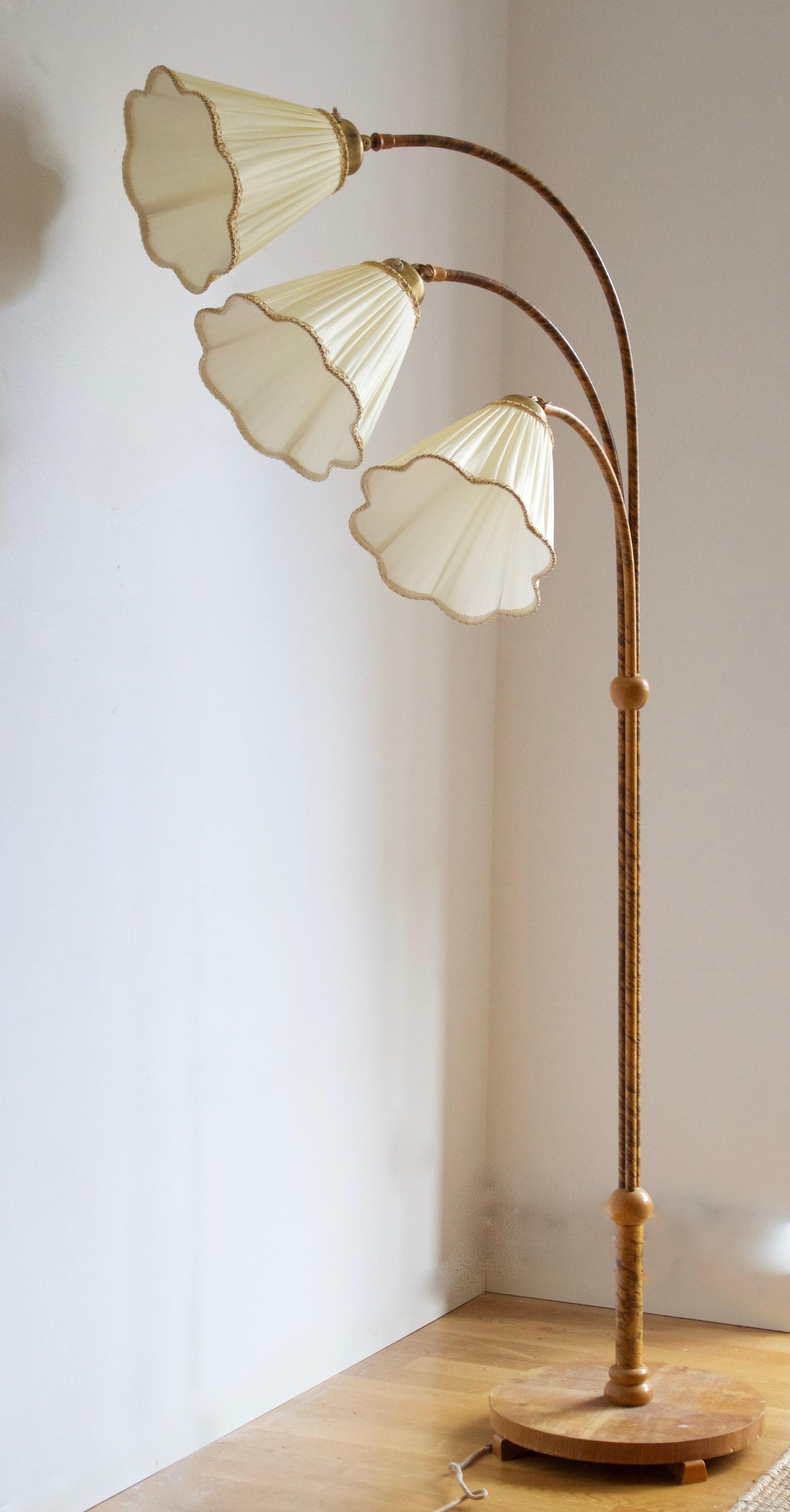 A three-armed floor lamp, designed and produced in Sweden, 1930s-1940s. Features wood, brass, wrapped bark, brand new high-end lampshades. 

Other designers of the period include Jean Royère, Paolo Buffa, Josef Frank, Jacques Adnet, and Paavo