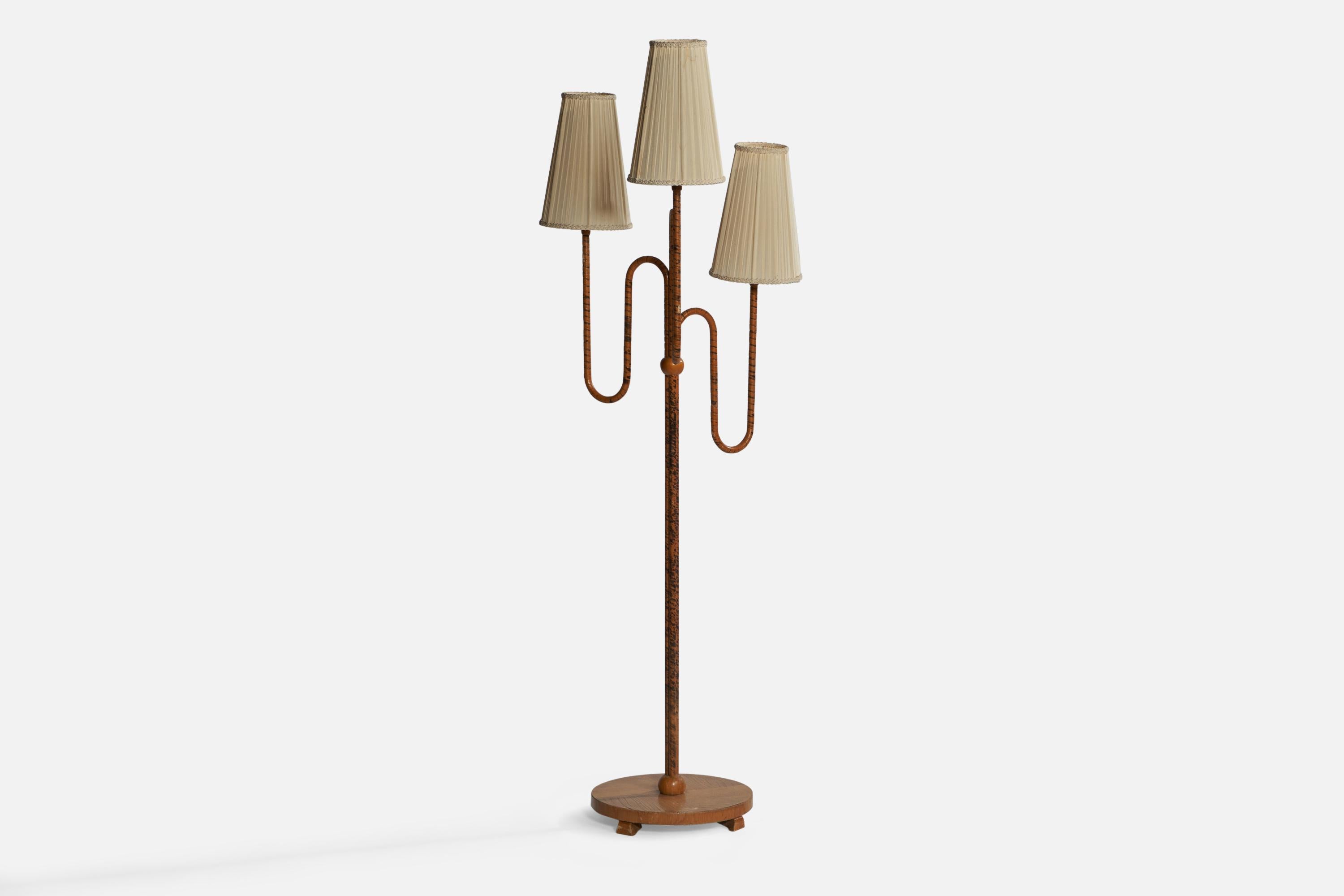 A three-armed elm, brass, off-white fabric and wrapped wood veneer floor lamp designed and produced in Sweden, 1930s.

Overall Dimensions (inches): 61.25” H x 22.5” W x 18.25” D. Stated dimensions include shades.
Dimensions vary based on on light