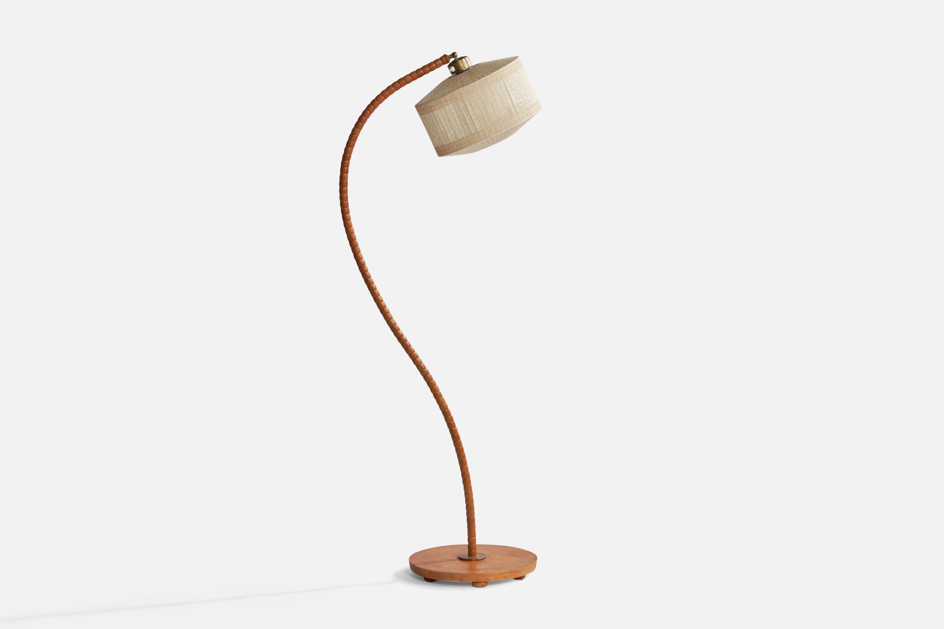 A curved oak, brass and off-white string fabric floor lamp designed and produced in Sweden, 1930s.

Overall Dimensions (inches): 62.5” H x 15.3” W x 24” D. Stated dimensions include shade.
Bulb Specifications: E-26 Bulb
Number of Sockets: 1
All