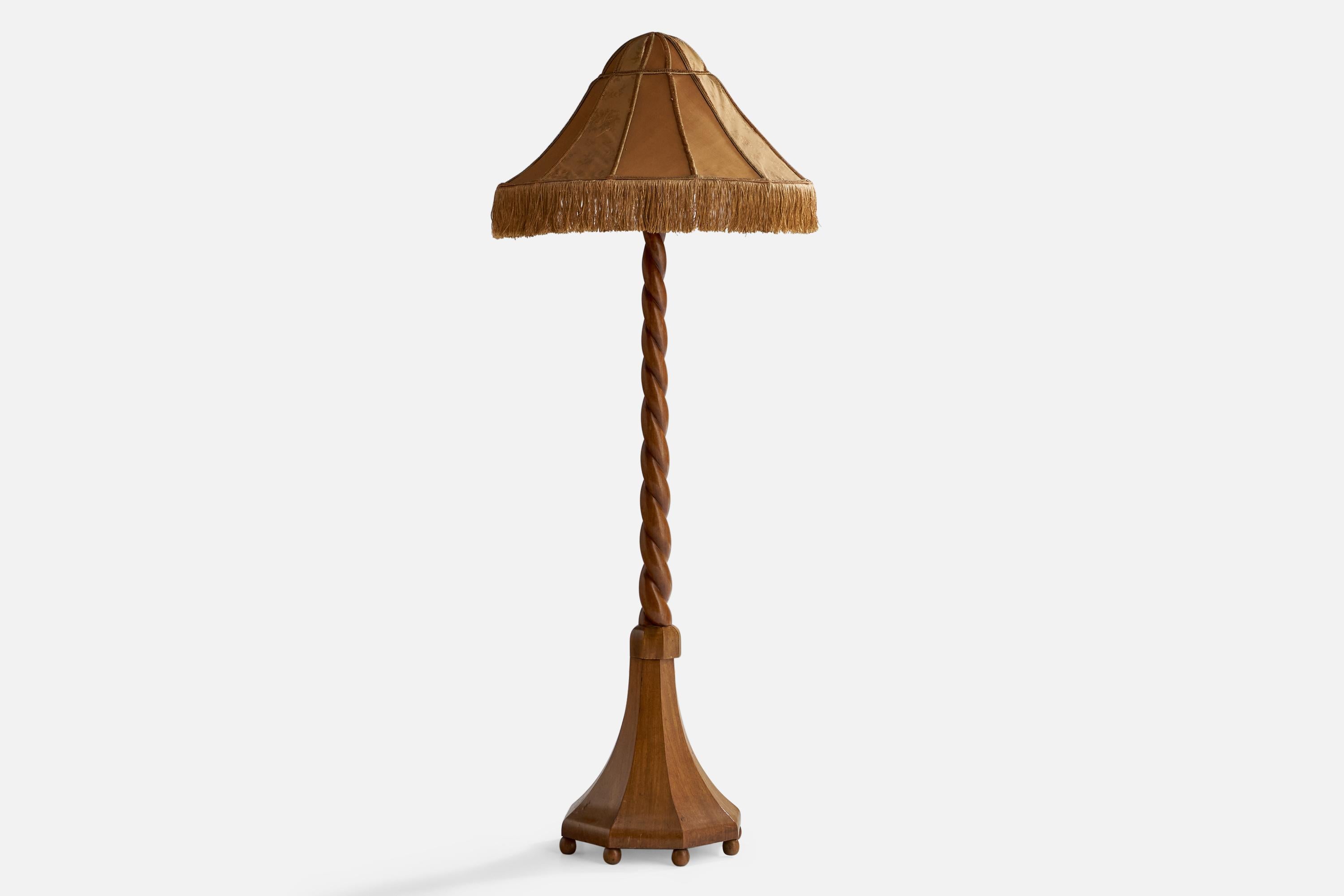 A carved oak and beige brown fabric floor lamp designed and produced in Sweden, c. 1910s.

Overall Dimensions (inches): 72” H x 28” Diameter
Bulb Specifications: E-26 Bulb
Number of Sockets: 2
 
All lighting will be converted for US usage. We are