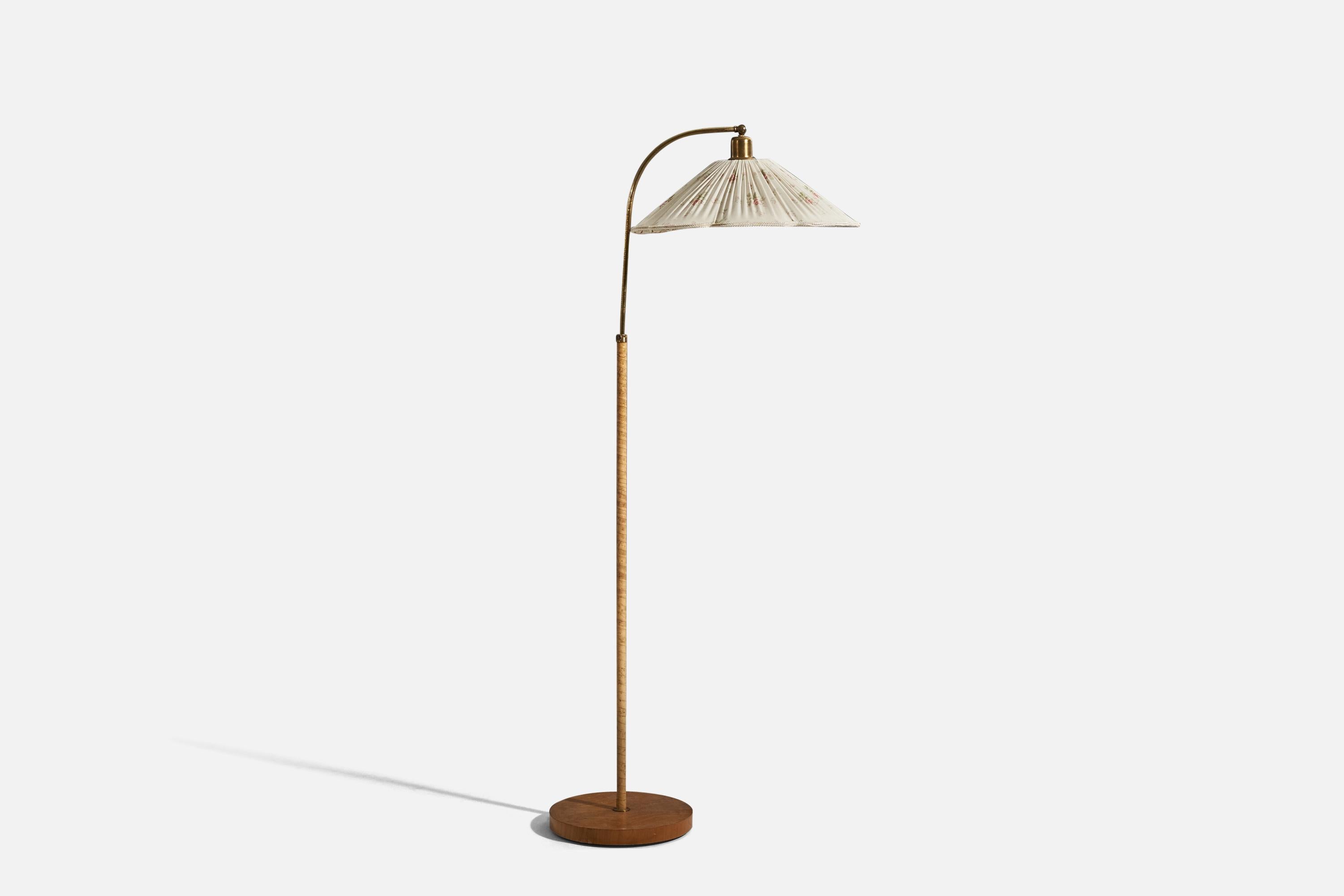 A brass, wood and fabric floor lamp designed and produced by a Swedish designer, Sweden, 1930s. 

Sold with lampshade. 
Dimensions stated refer to the floor lamp with shade. 
Variable dimensions, measured as illustrated in the first image.