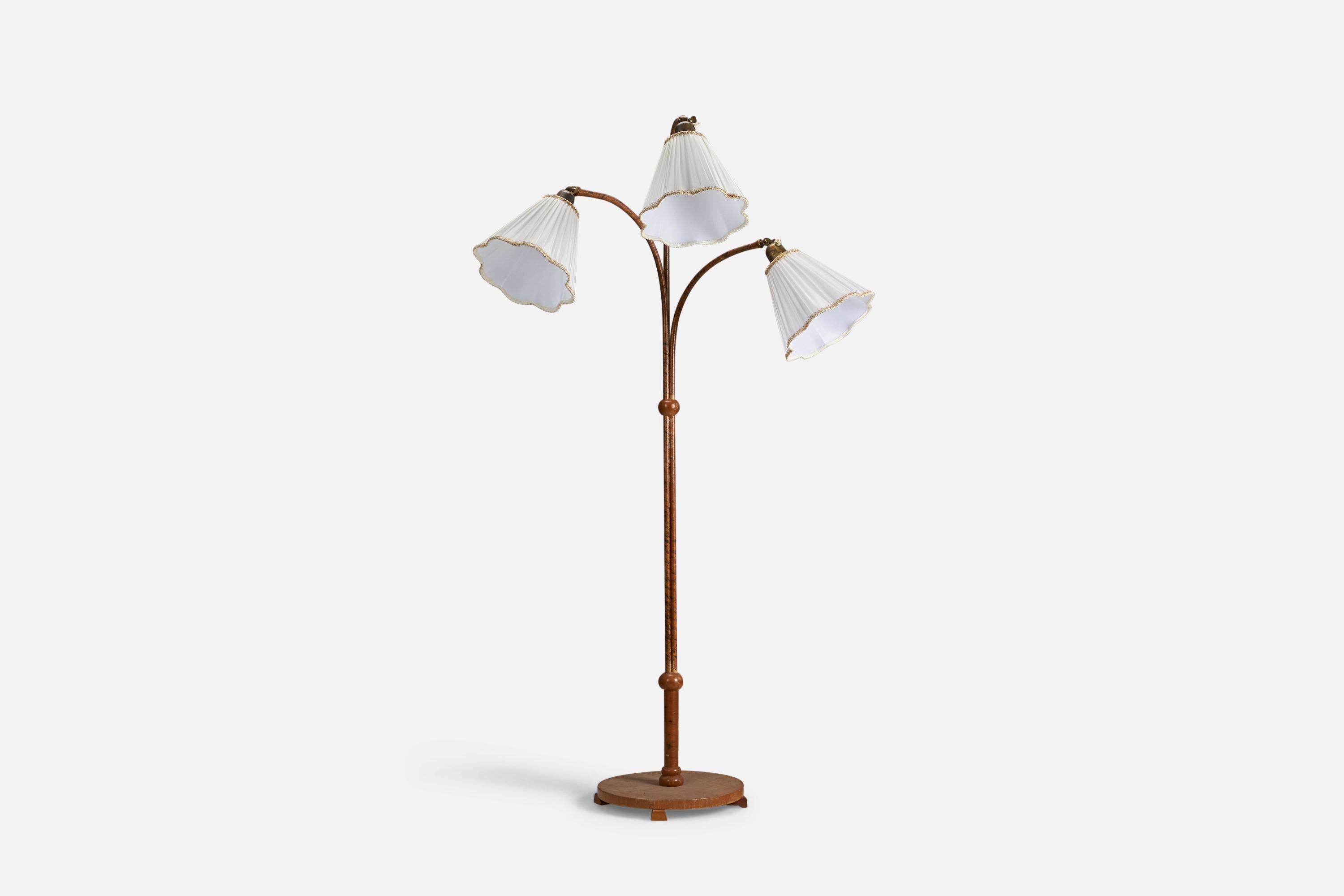 A wood, wood veneer, brass and fabric floor lamp designed and produced by a Swedish Designer, Sweden, 1940s.

Sockets take standard E-26 medium base bulbs.

There is no maximum wattage stated on the fixture.