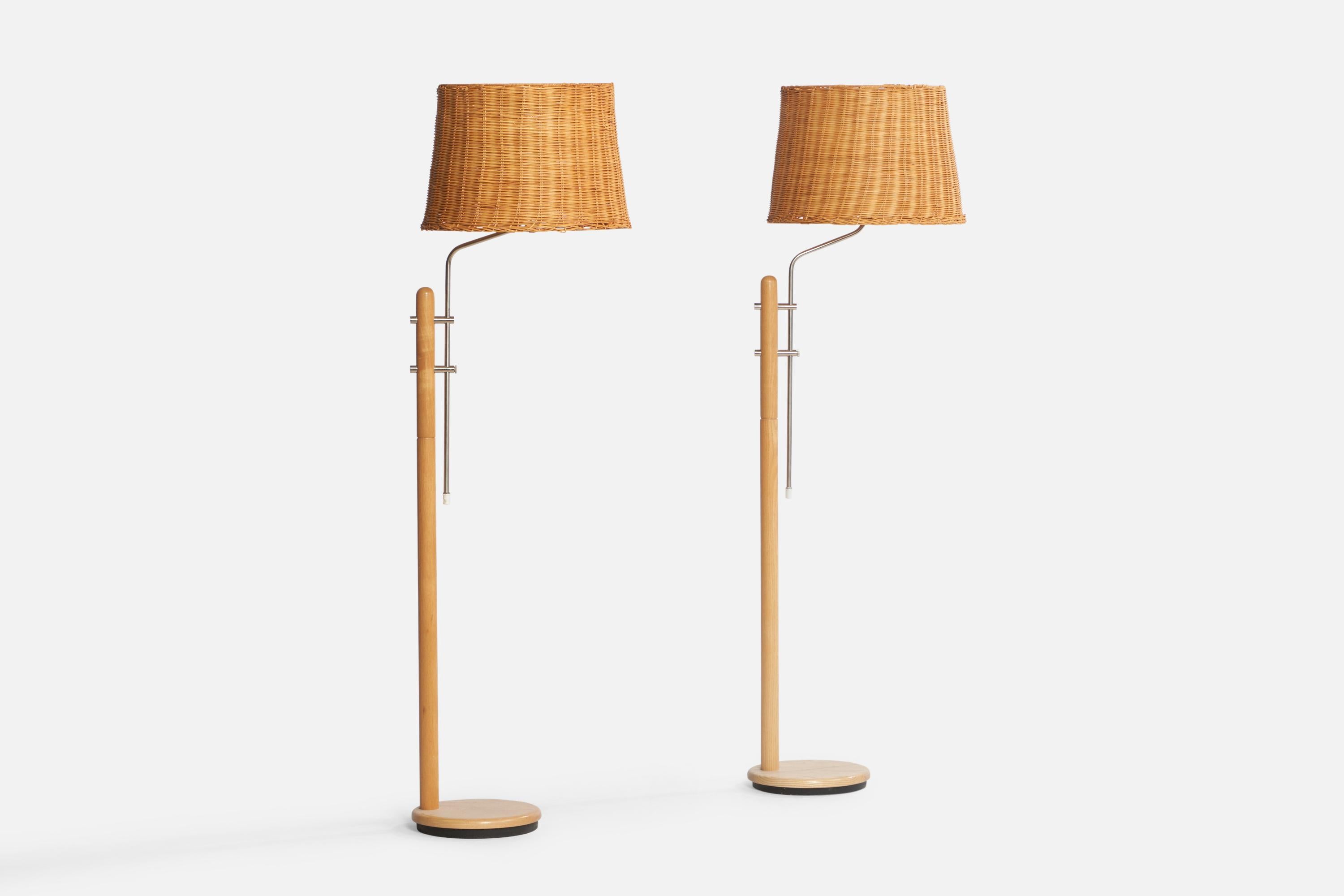 A pair of adjustable pine, steel and rattan floor lamps designed and produced in Sweden, c. 1970s.

Overall Dimensions (inches): 60” H x 16.5” W x 18” D. Stated dimensions include shades. 

Note slight variation in wood color.
Bulb Specifications: