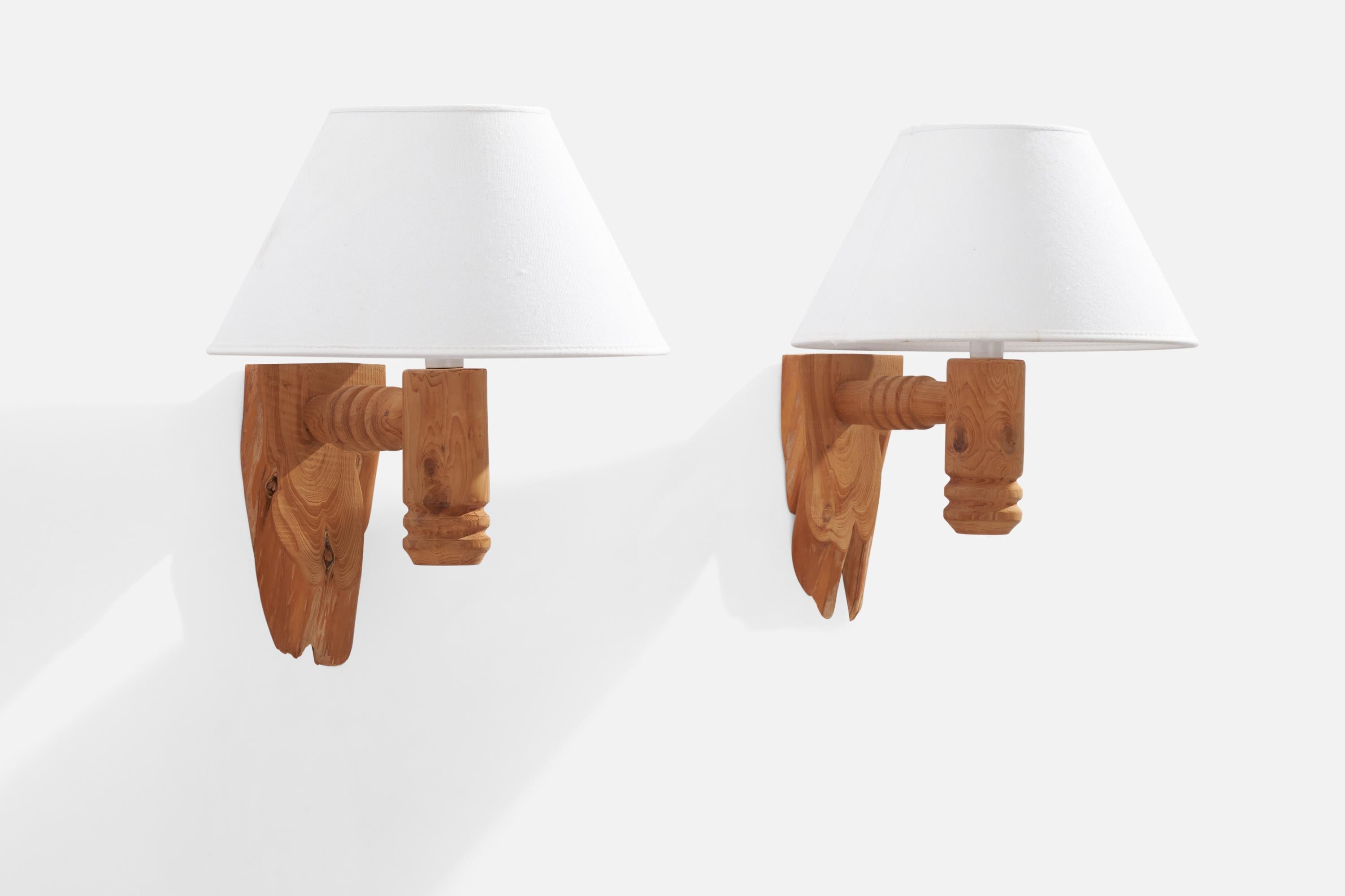 A pair of freeform pine and white fabric wall lights designed and produced in Sweden, 1970s.

Overall Dimensions (inches): 11.75” H x 8” W x 9.25” D
Back Plate Dimensions (inches): N/A
Bulb Specifications: E-14 Bulb
Number of Sockets: 2
All lighting