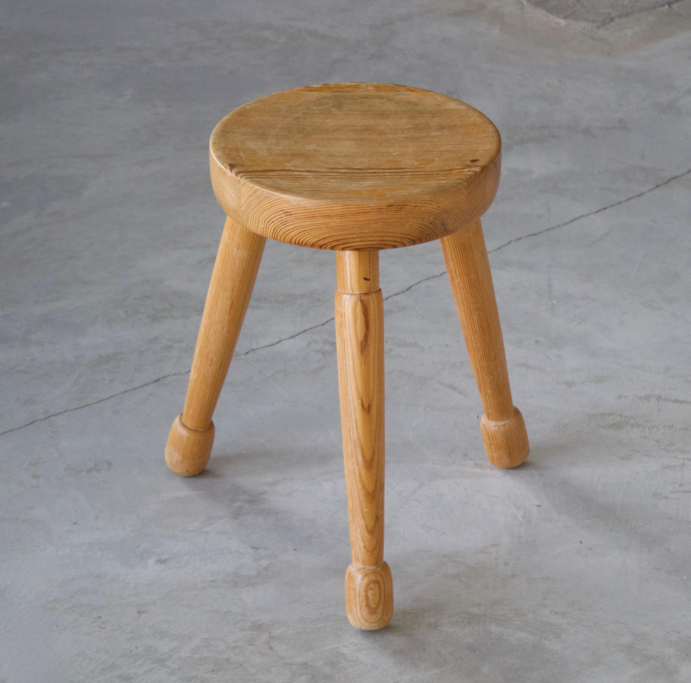 A Swedish pinewood stool or side table. By unknown designer, branded text and dated 1976. Original paper label indicating stool is handcrafted.





