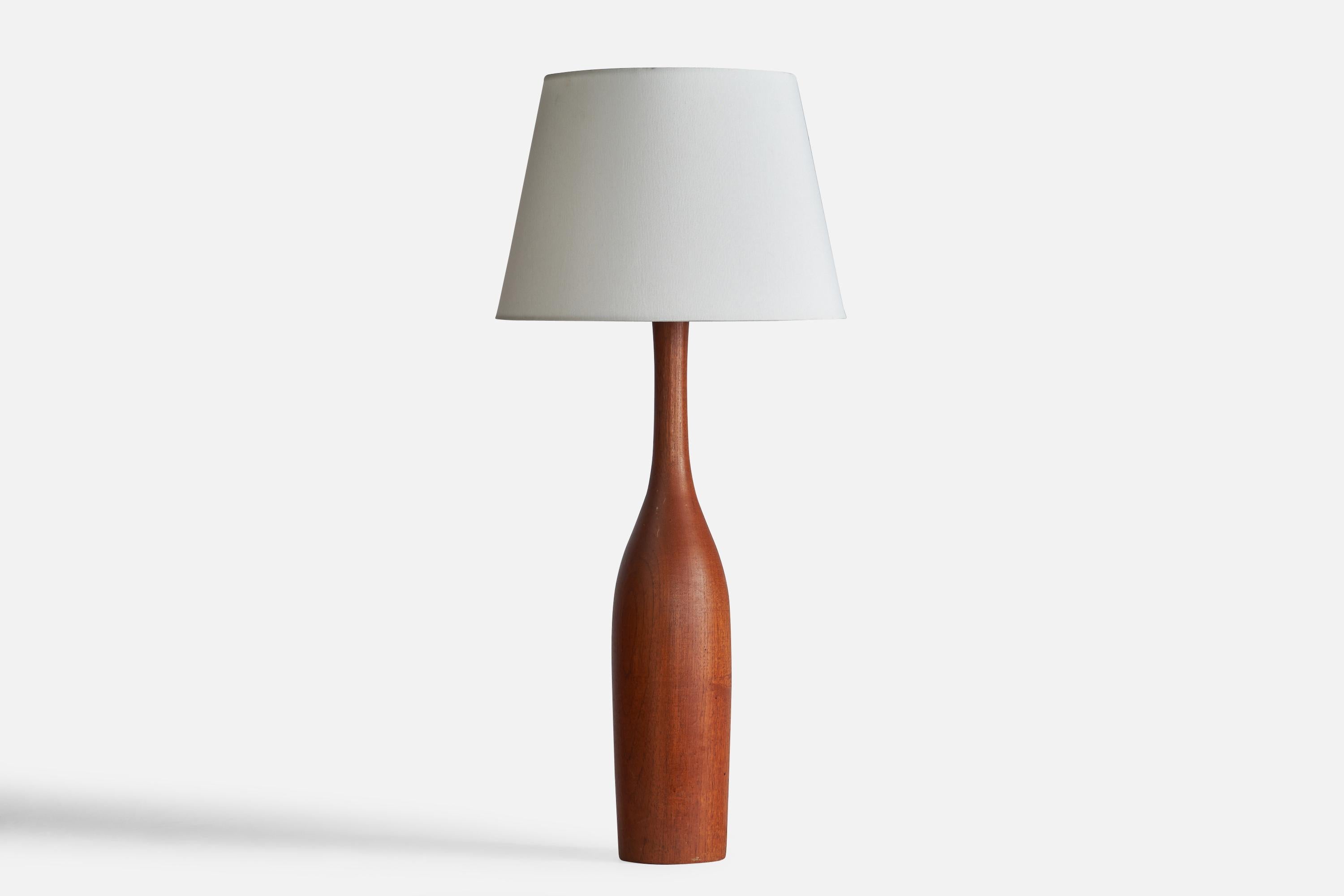 A large teak and brass table lamp designed and produced in Sweden, 1960s.

Dimensions of Lamp (inches): 24.5” H x 4.75” Diameter
Dimensions of Shade (inches): 9” Top Diameter x 12” Bottom Diameter x 9” H
Dimensions of Lamp with Shade (inches):