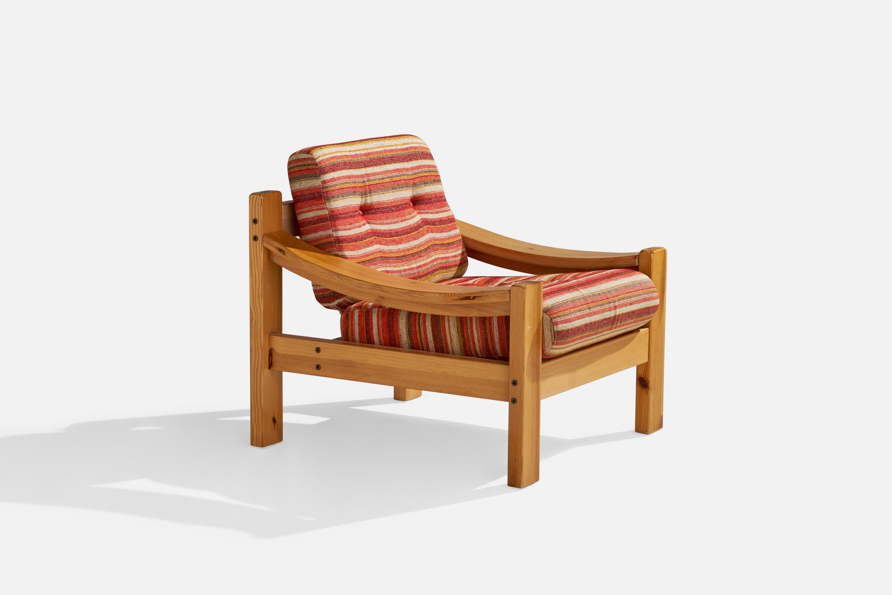 A pine and red fabric lounge chair designed and produced in Sweden, 1970s.

seat height 17.33”.