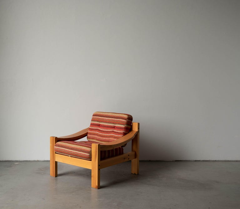 A lounge chairs. Designed and produced in Sweden, 1970s. Cushion upholstered in fabric and fitted with buttons.


