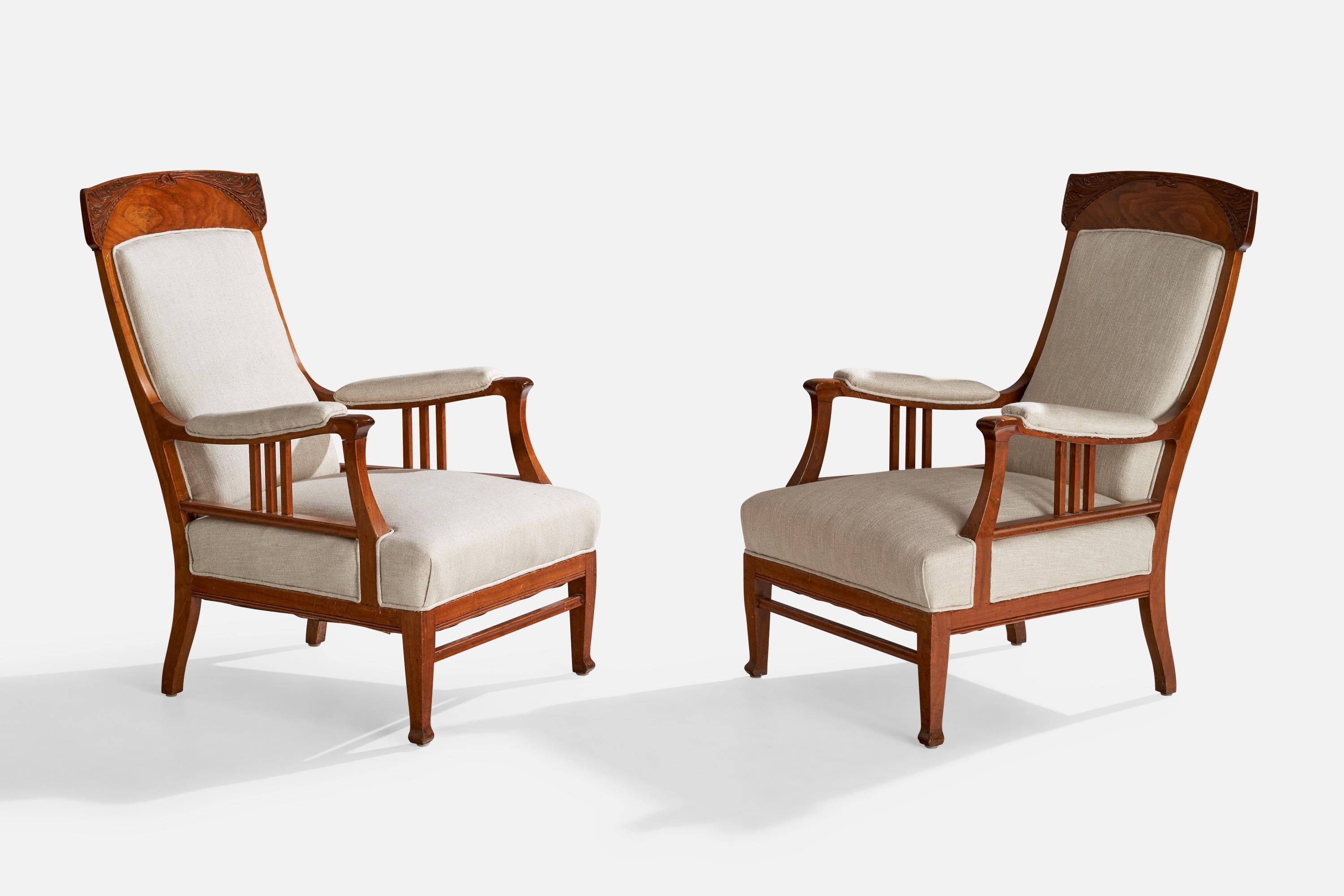 A pair of stained oak and white fabric lounge chairs designed and produced in Sweden, c. 1900s.

Dimensions: 41” x 25.25” W x 34” D

Seat height: 17”