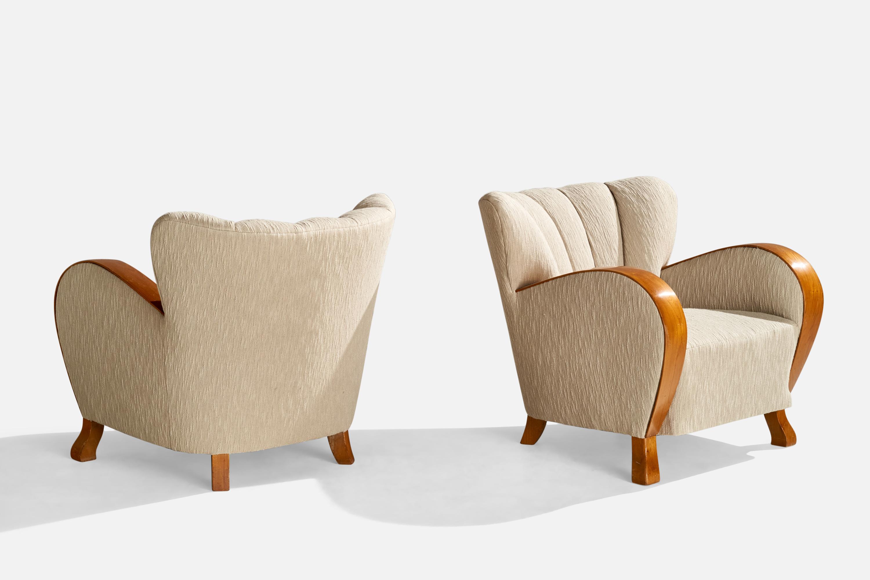 A pair of oak and fabric lounge chairs designed and produced in Sweden, c. 1930s.

Seat height: 15.5”
Arm height: 23”
