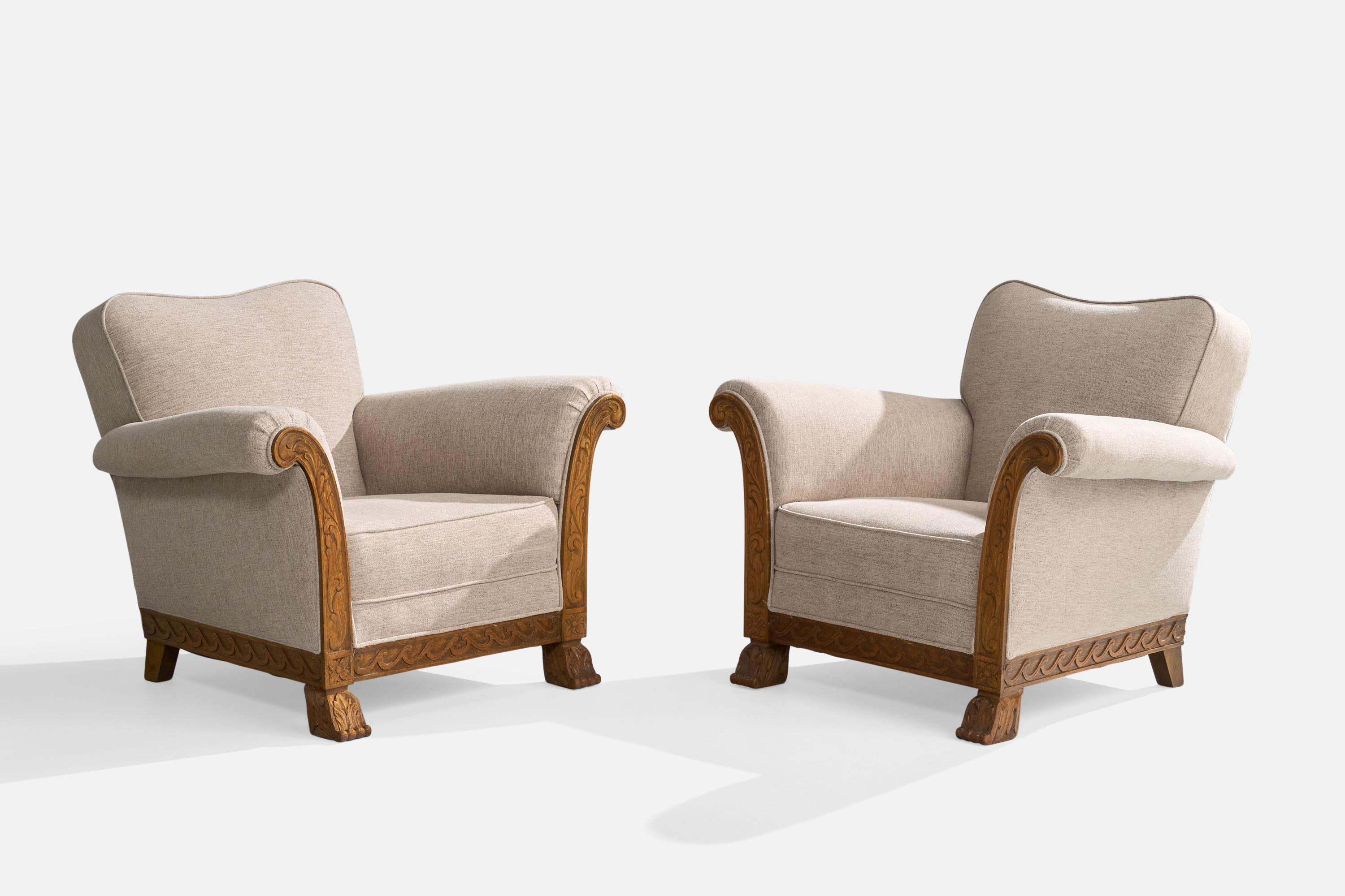A pair of craved oak and light-grey fabric lounge chairs designed and produced in Sweden, c. 1940s.

Overall Dimensions (inches): 32” H x 38” W x 34” D

Seat Height (inches): 15”

Arm Height (inches): 24.8”

All upholstered furniture can be