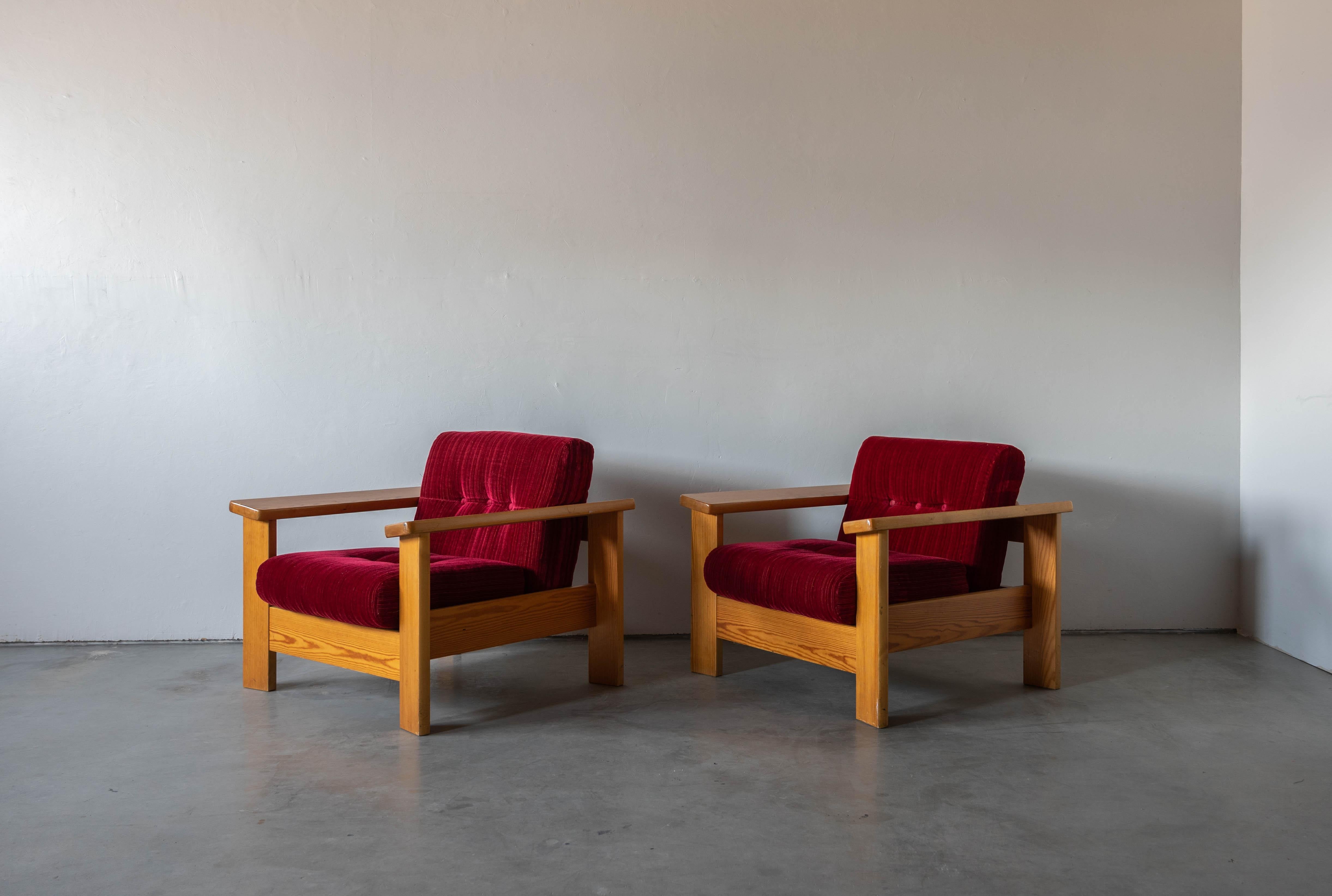A pair of lounge chairs. Designed and produced in Sweden, 1970s. Cushion upholstered in fabric and fitted with buttons.

