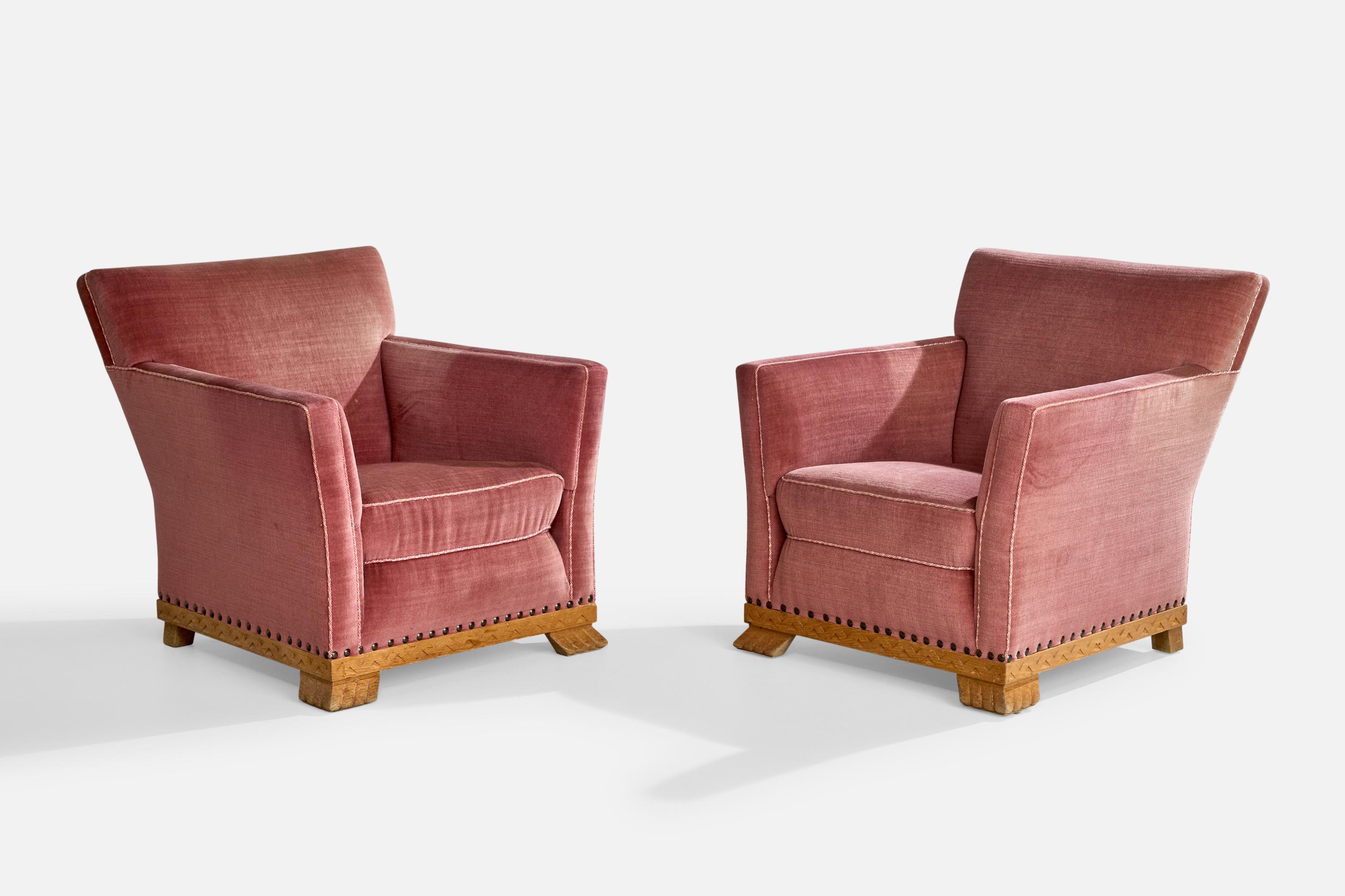 A pair of pink velvet and oak lounge chairs designed and produced in Sweden, c. 1930s.

Vintage fabric with staining and sun-fading, ideally reupholstered.

Dimensions: 32” H x 29.75” W x 32” D

Seat Height: 15.75”