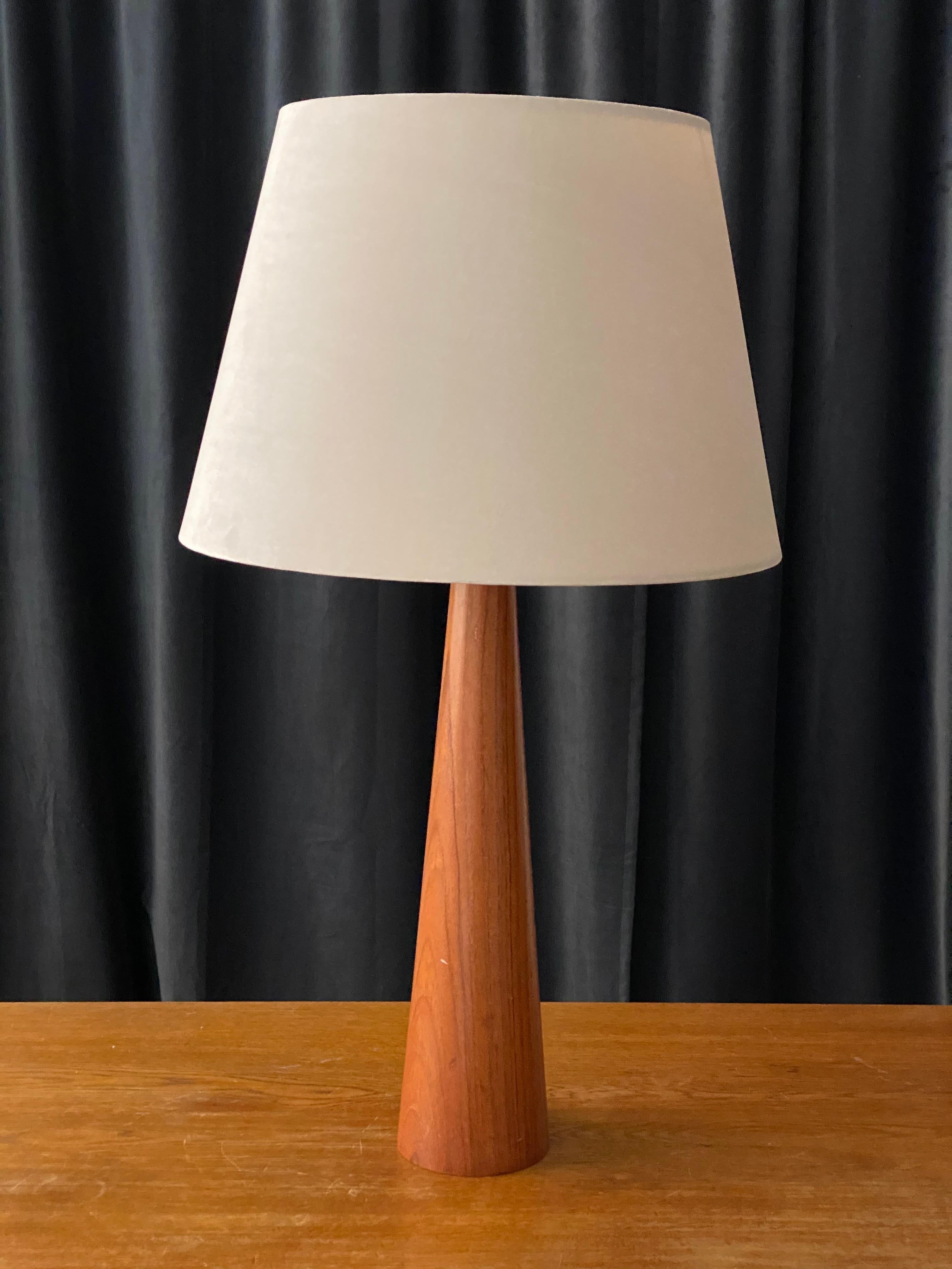 A mid-century modernist table lamp / desk light. In solid carved and finely sculpted teak. Marked 