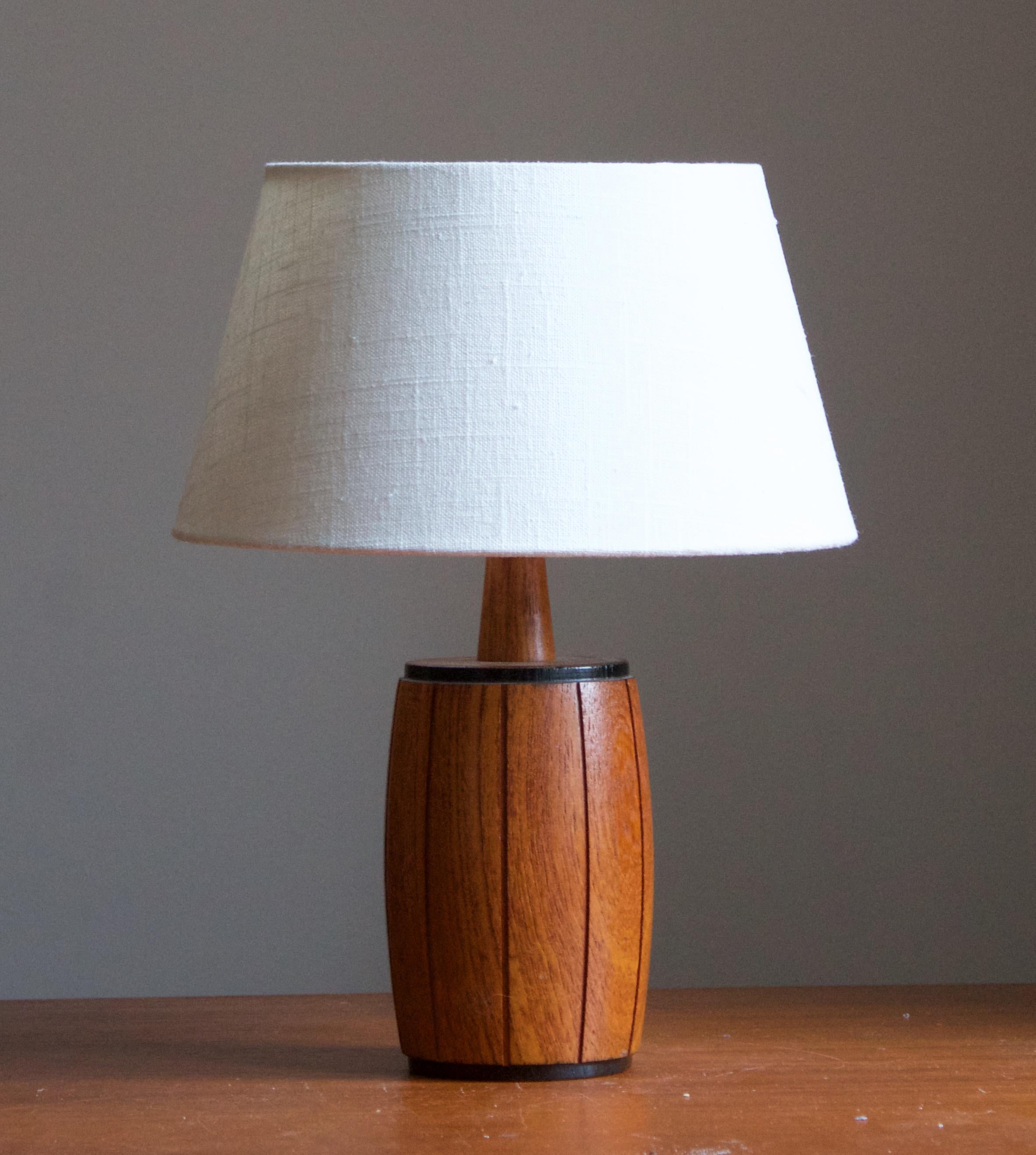A table lamp. In solid turned teak. By unknown Swedish designer and producer, c. 1960s.

Stated dimensions exclude lampshade, height includes the socket. Sold without lampshade.